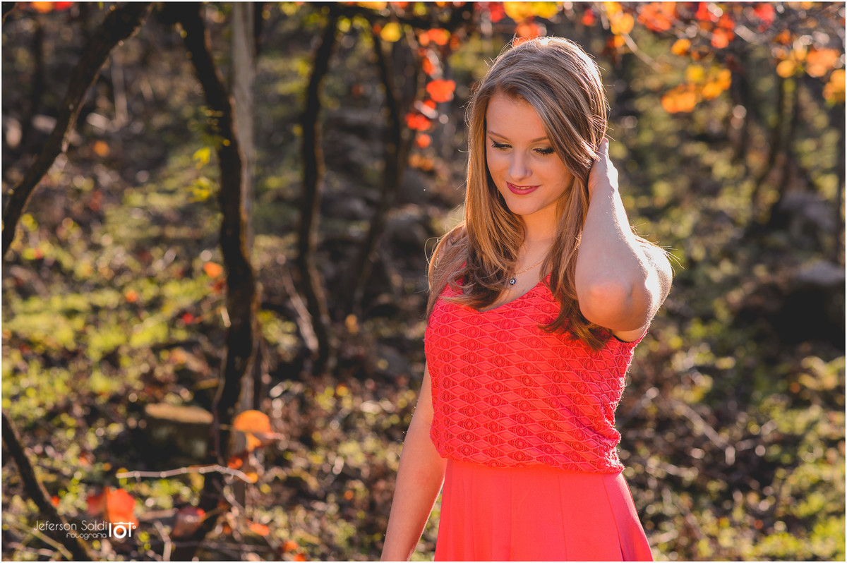 Elisa pousando com seu vestido laranja no meio do parreiral