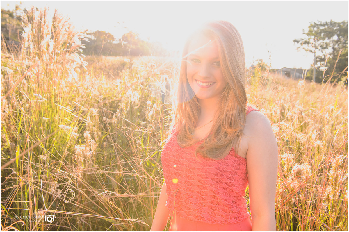 Elisa no meio dos capins com o flare entrando na lente