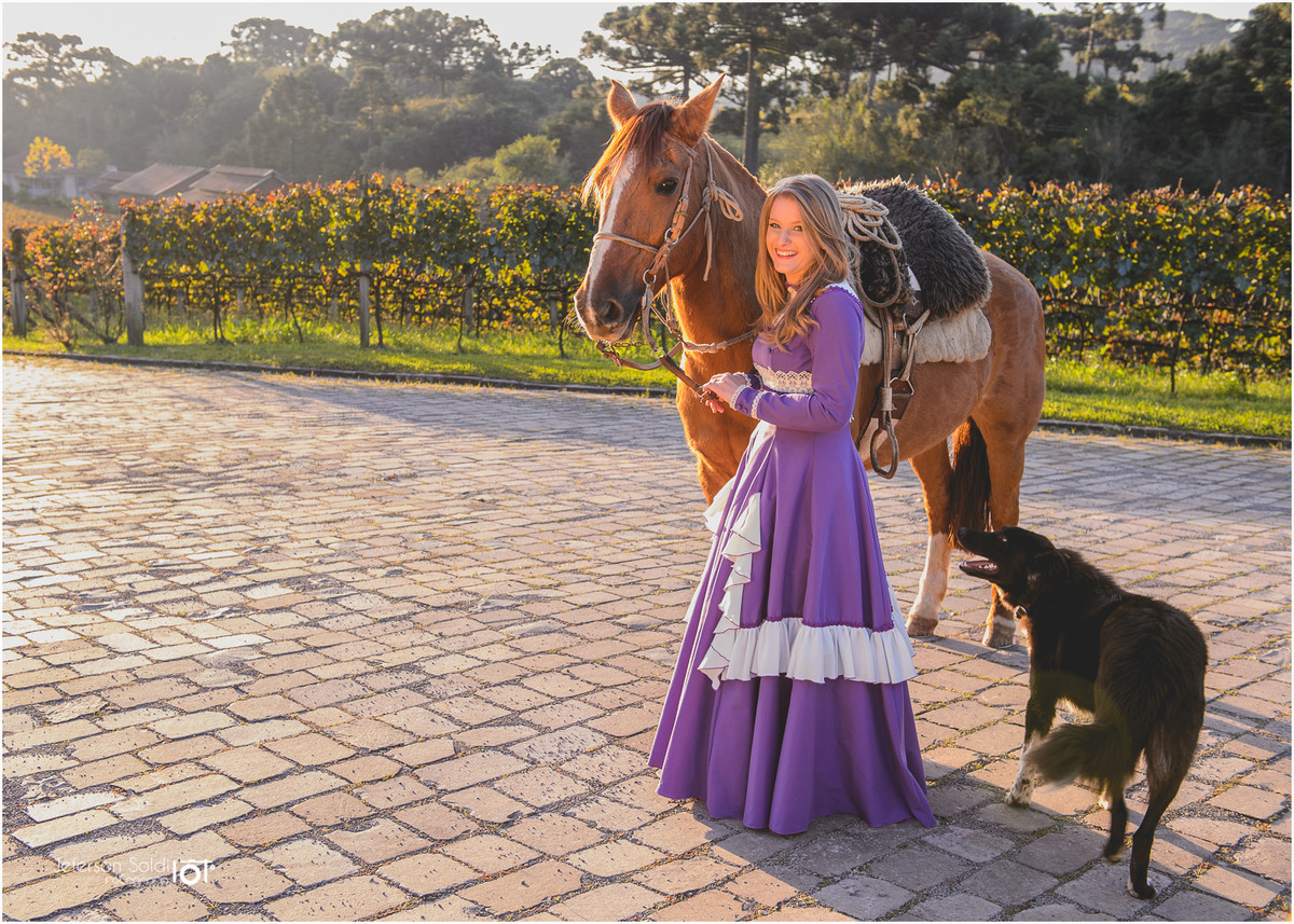 Elisa com seu vestido gaúcho ao lado do seu cavalo e o seu cachorro ao lado