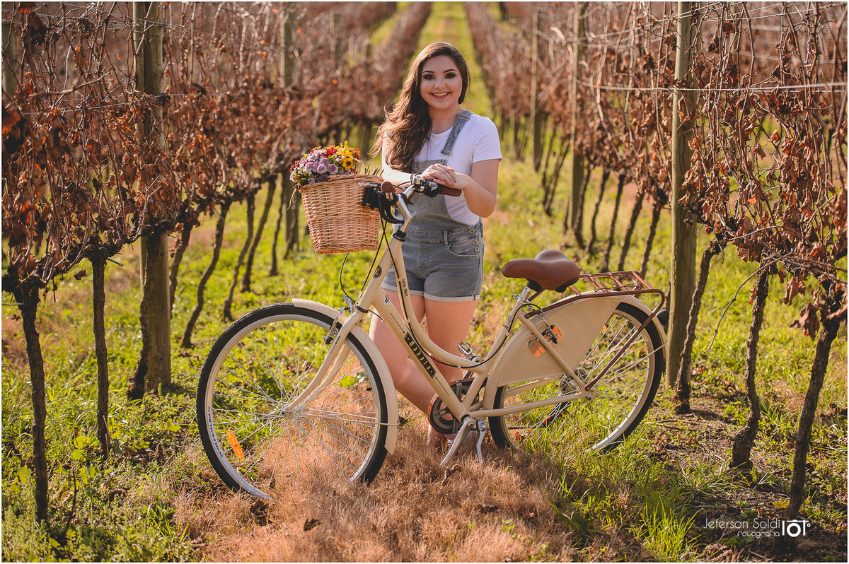 Julia com sua bicicleta em meio aos parreirais no vale dos vinhedos