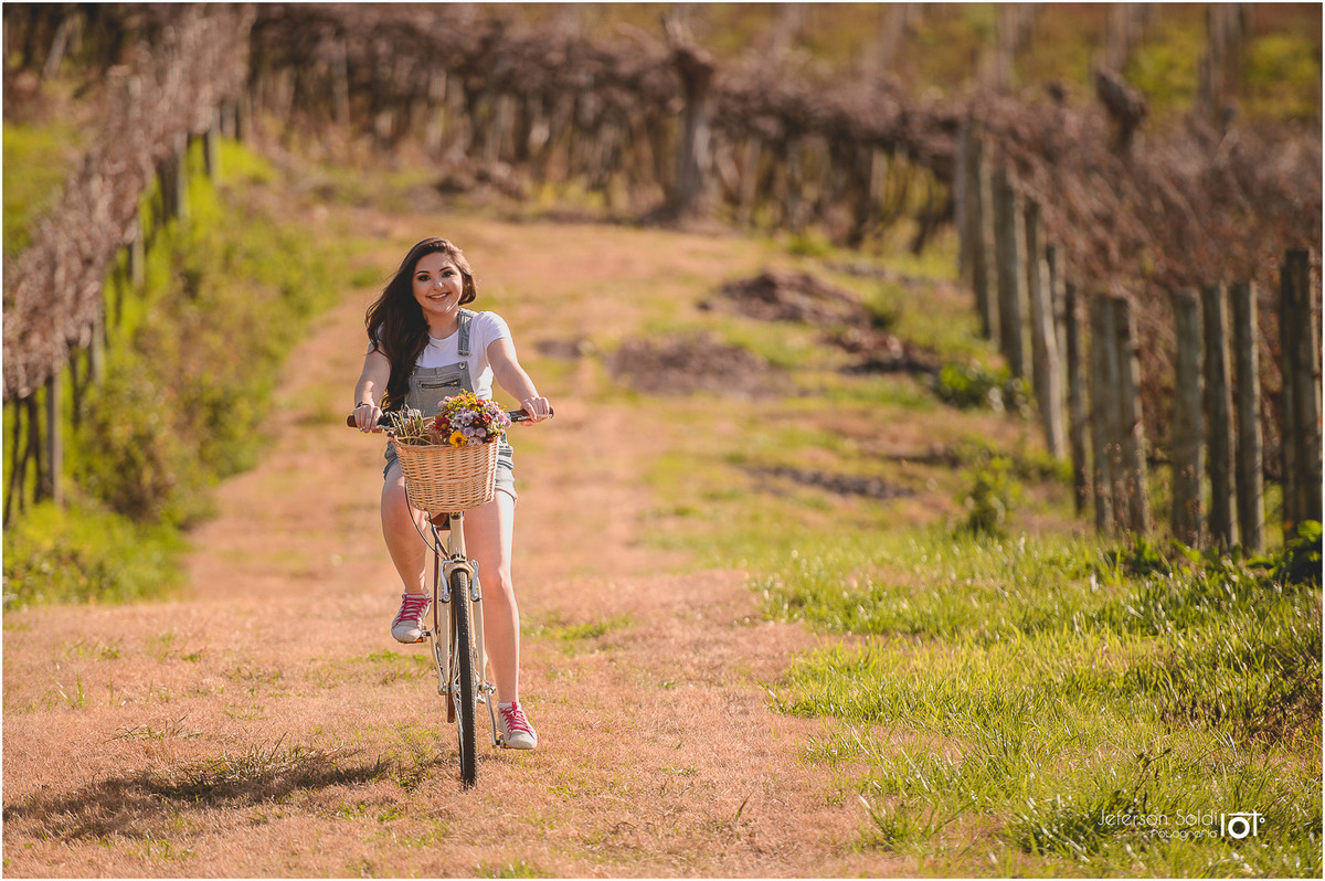 Julia andando de bicicleta pelos parreirais no vale dos vinhedos