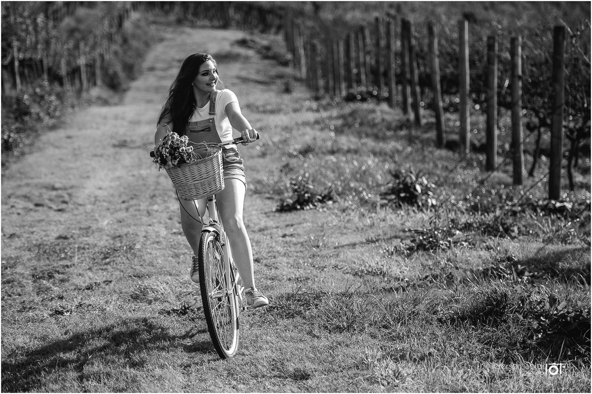 Julia em sua bicicleta em meio aos parreirais no outono