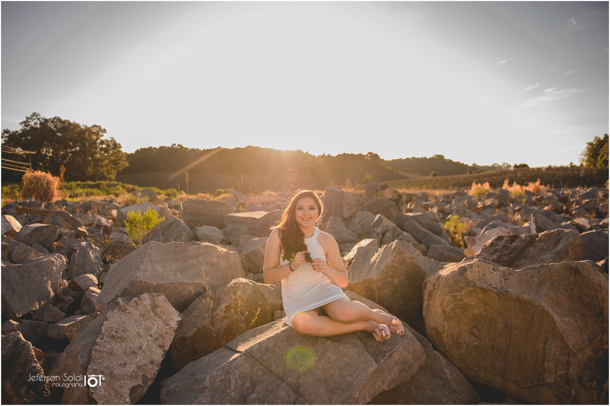 Julia sentada em uma pedra no vale dos vinhedos