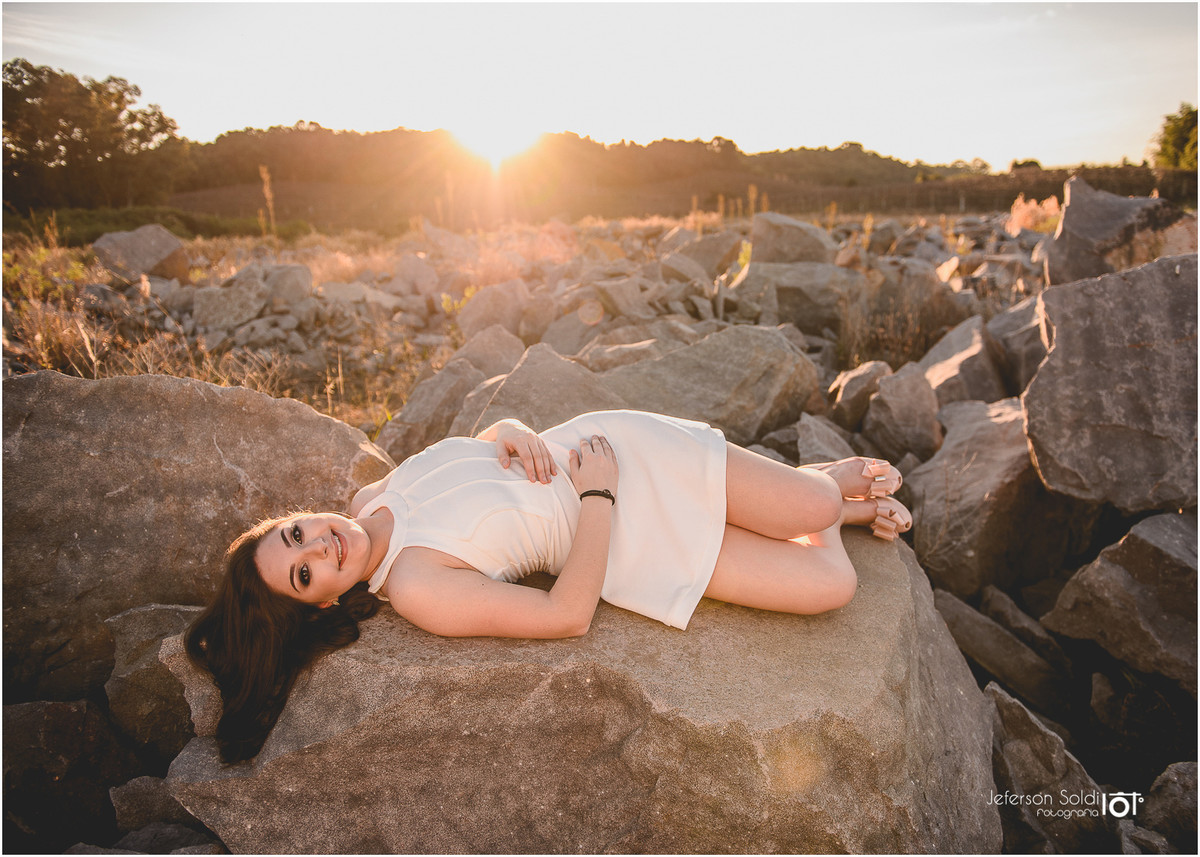 Julia deitada em uma pedra sob raios de sol