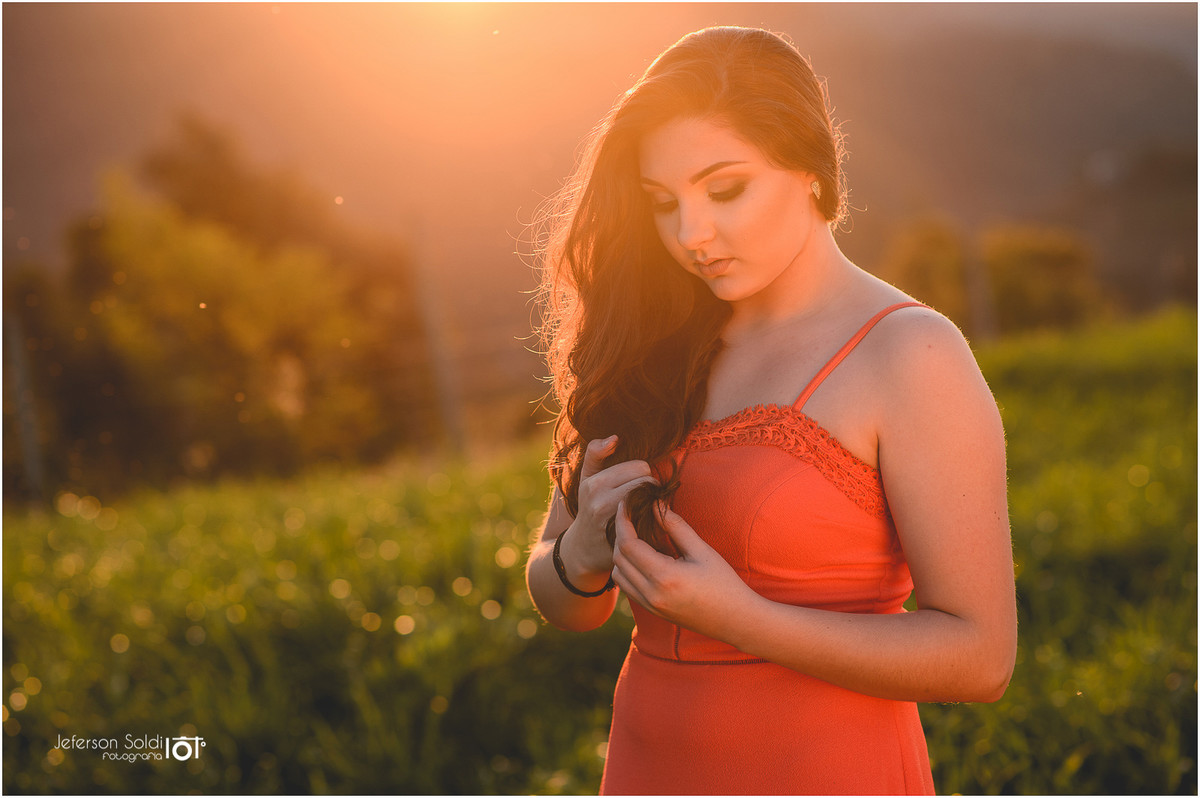 Julia em meio a natureza mexendo nos cabelos