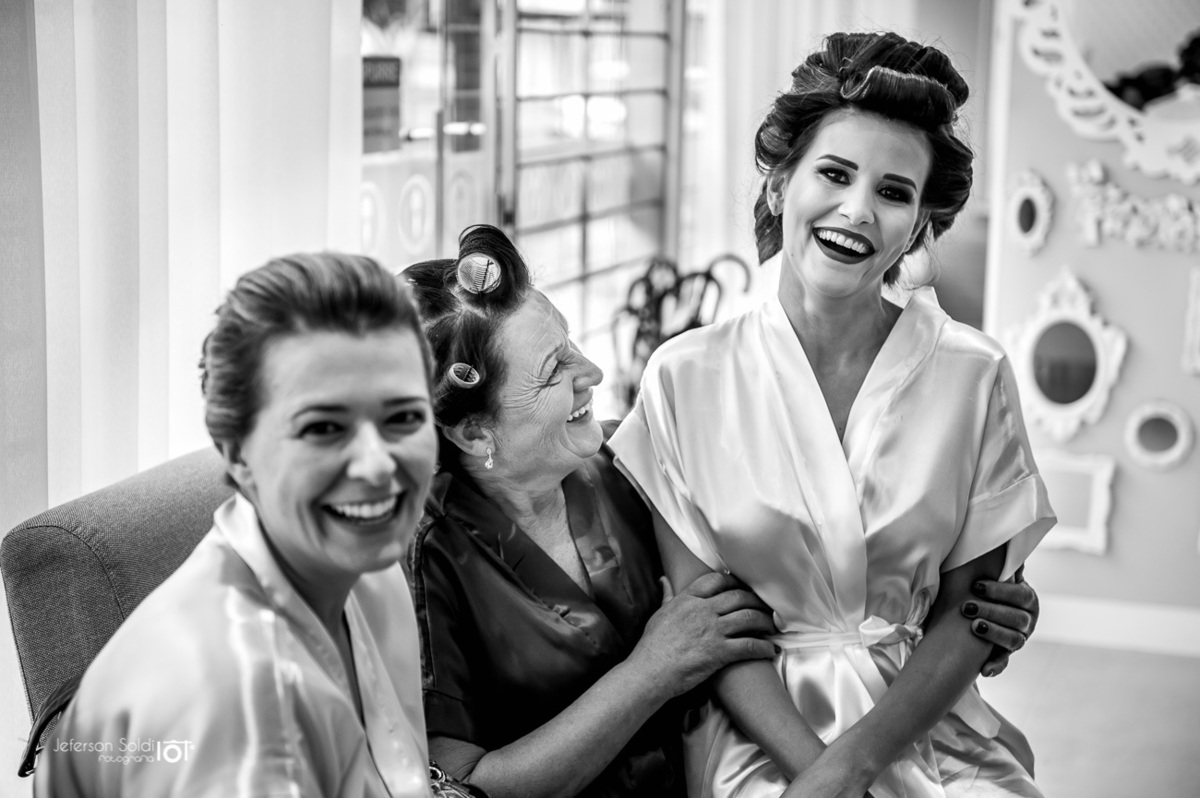 Noiva sentada no colo da sogra em um momento lindo de descontração.