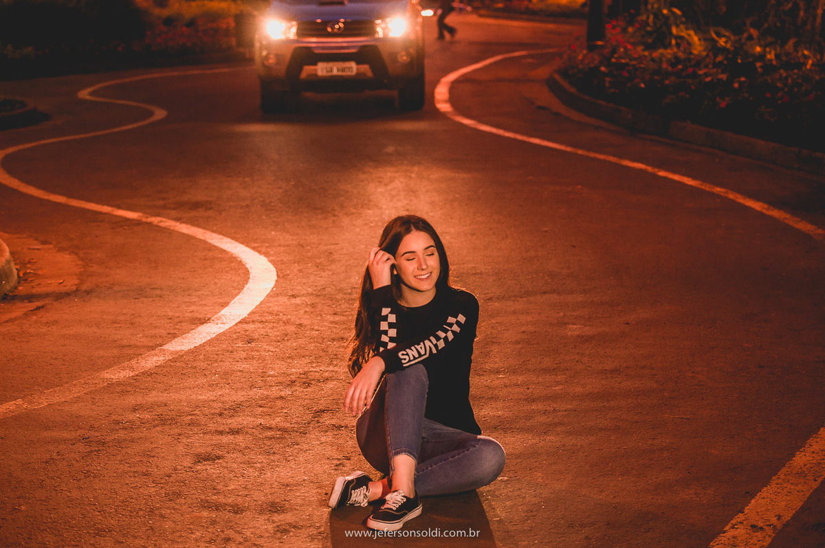 Laura sentada no chão da rua torta em gramado