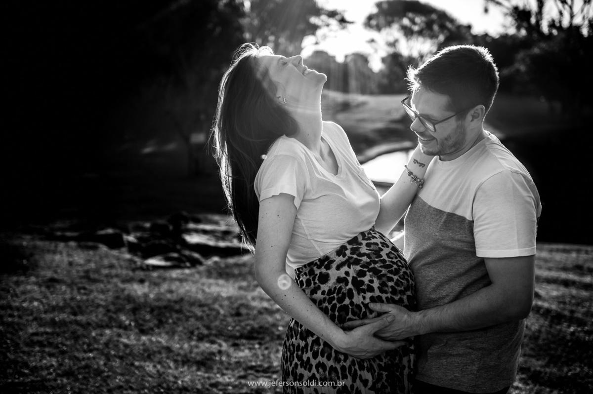 Casal de gestantes, mamãe sorrindo enquanto papai contempla a linda barriga