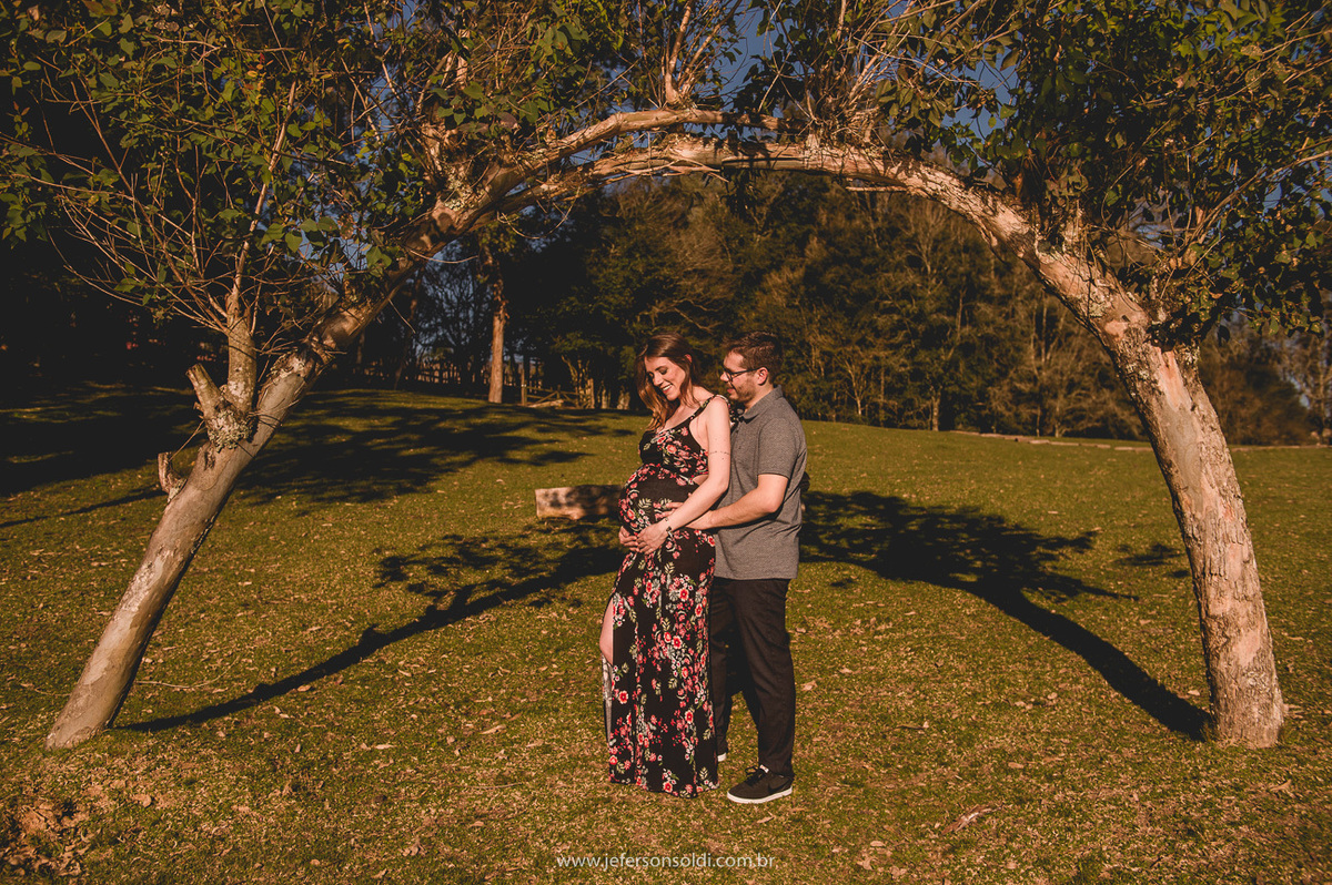 casal de gestante abraçados e admirando a barriga linda da mamãe