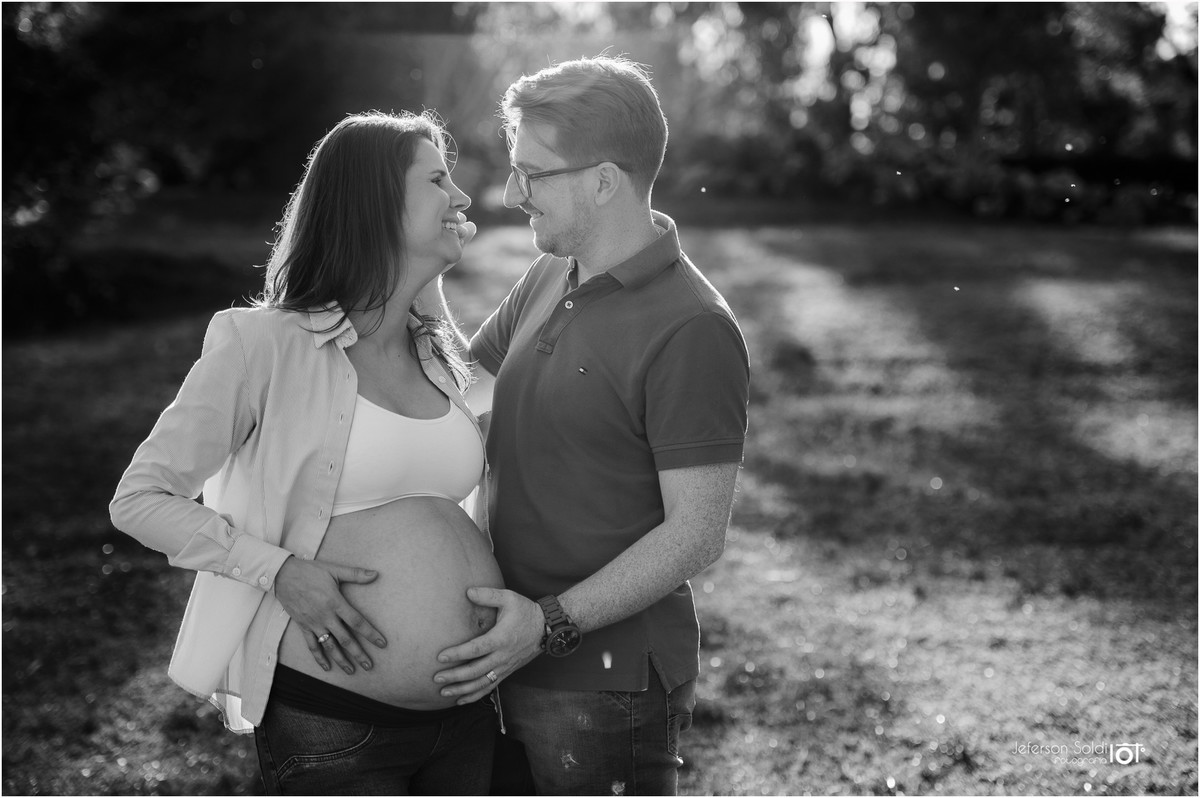 Casal se olhando acariciando a barriga em preto e branco