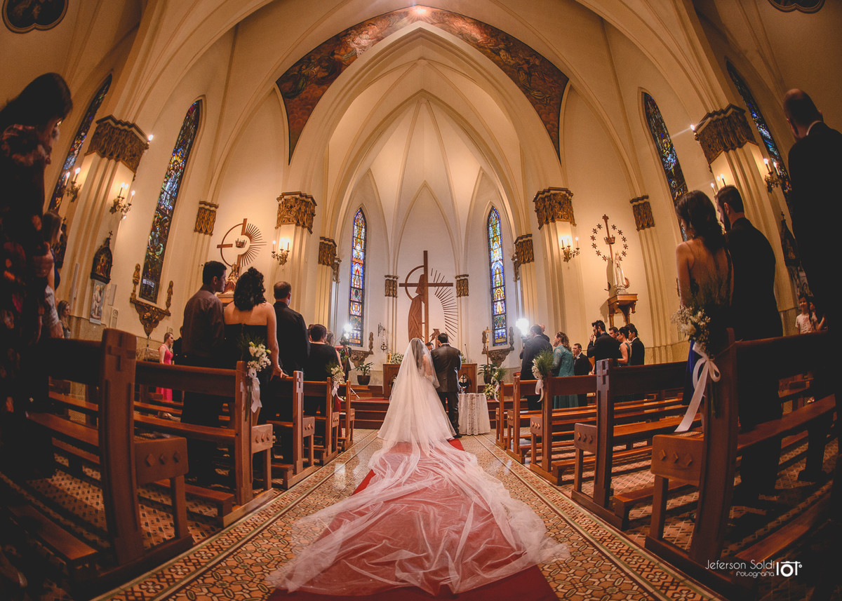 Foto feita dos noivos no altar com angulo que mostre o véu da noiva