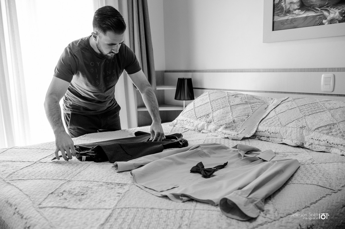 Noivo verificando a roupa do casamento em cima da cama