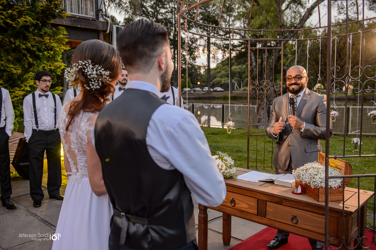 Noivos no altar escutando o pastor