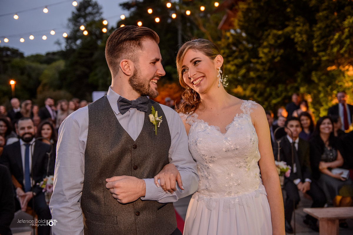Noivos se olhando e sorrindo em frente ao altar