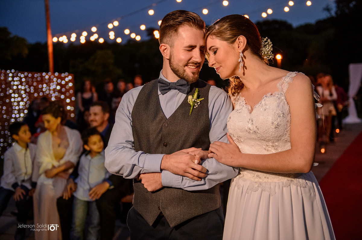 Casal de braços dados e rosto colado