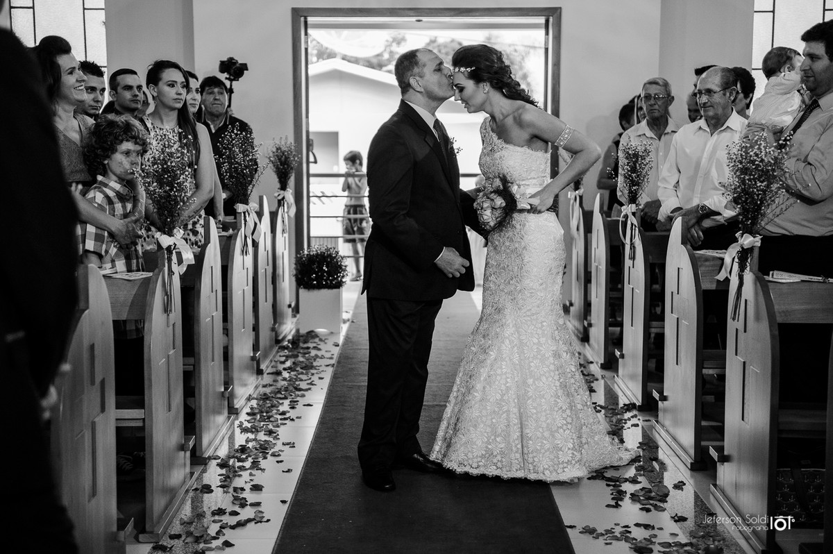 Pai beija a testa da noiva antes de entrega-la no altar.