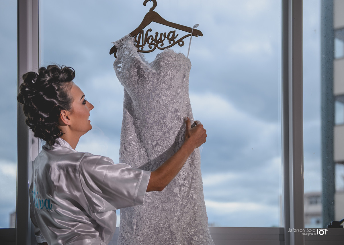 Noiva verificando o vestido no cabide.