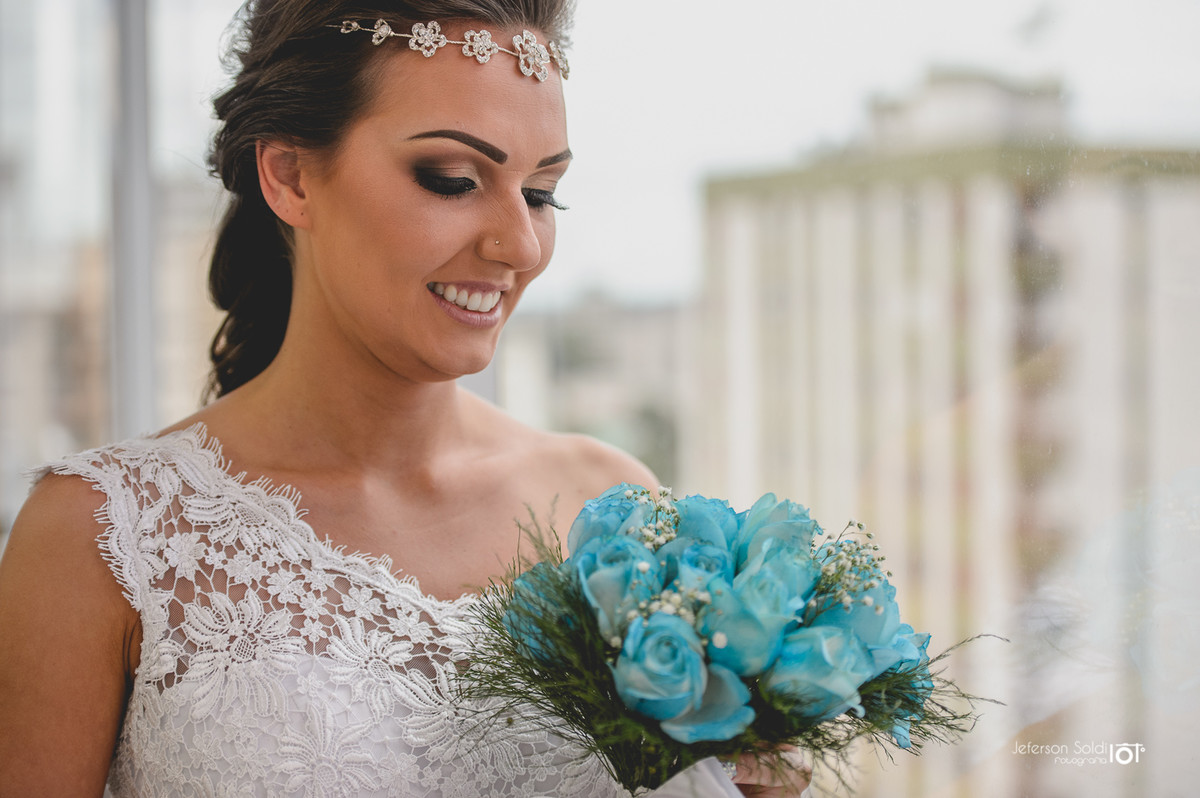 Noiva olhando para o bouquet.