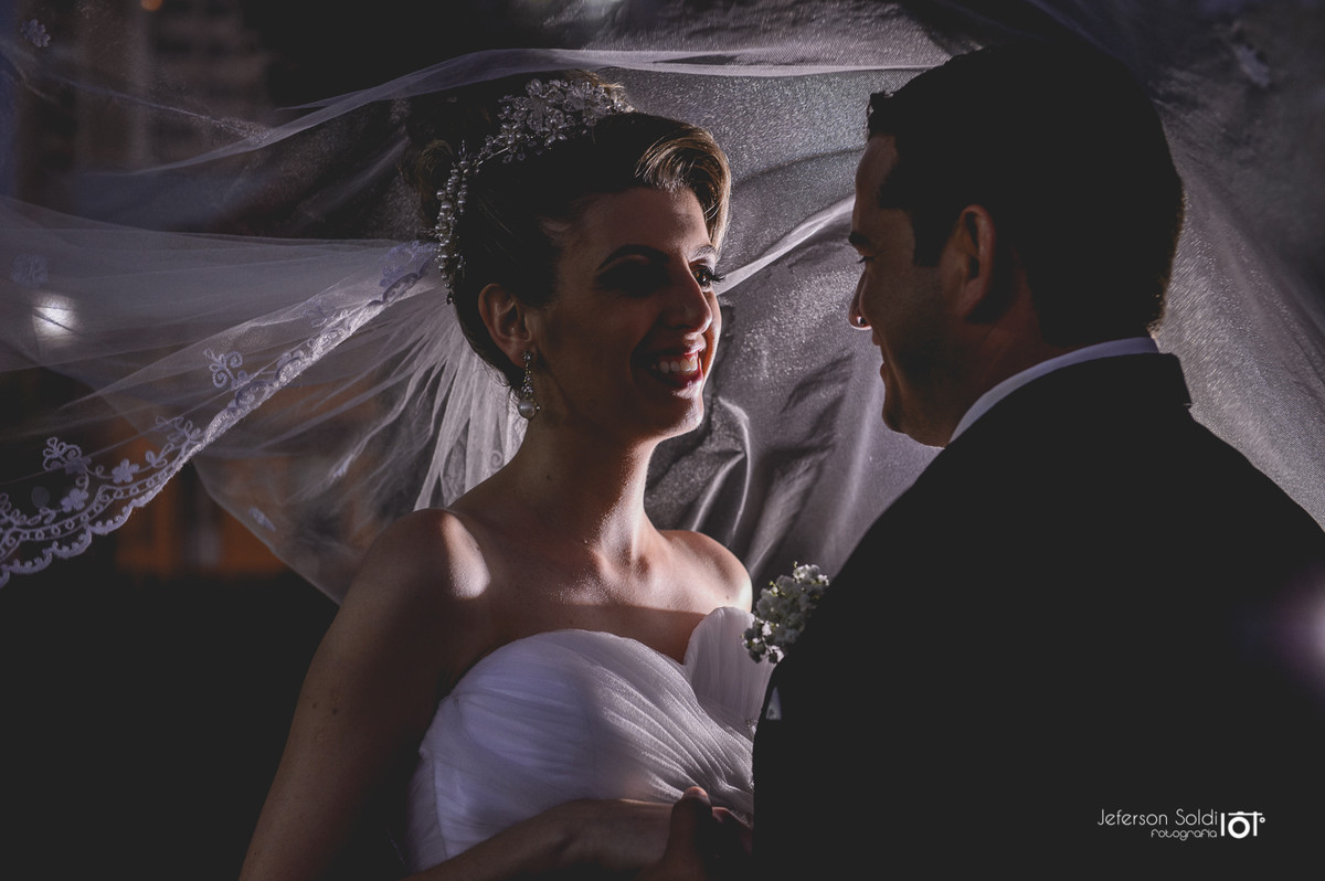 Noivos de mãos dadas se olhando.