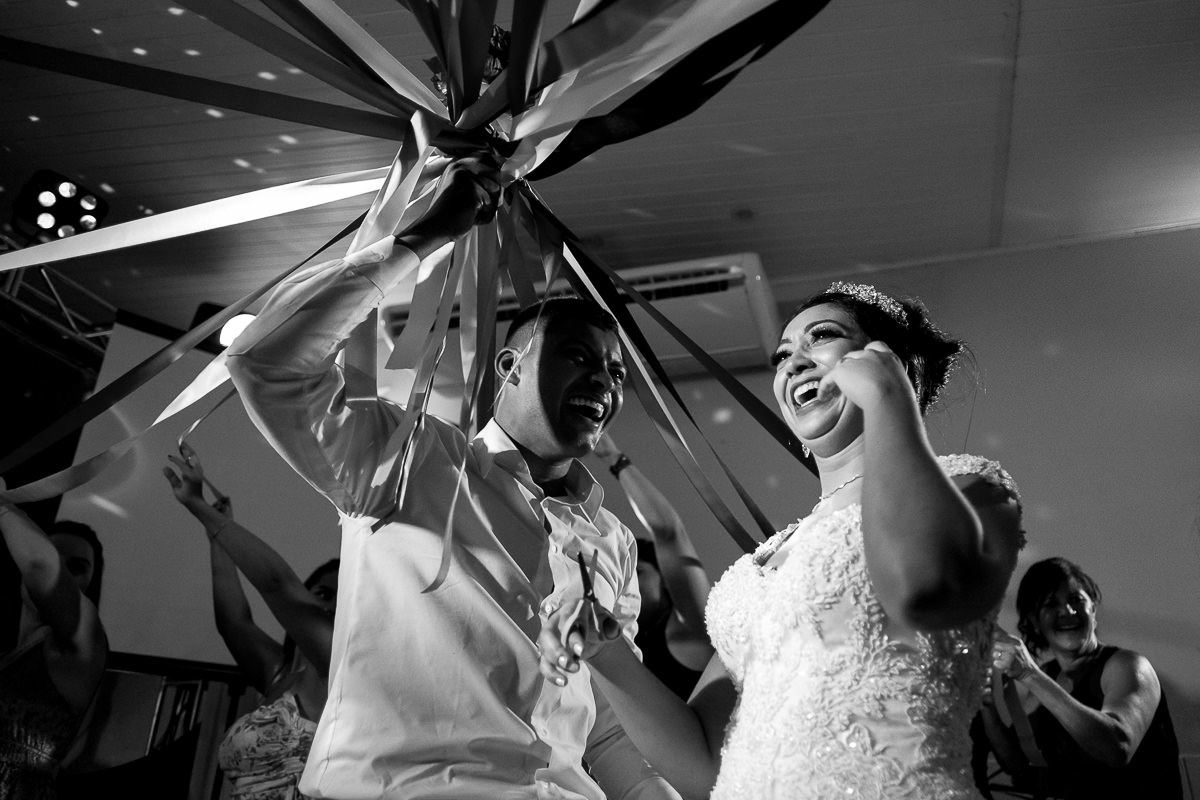 noivo e noiva jogando o buquê em casamento por Alice Casaes fotógrafa de Guarujá