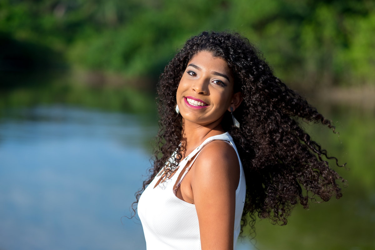 Ensaio debutante Ana Flávia olhando e sorrindo na Praia das Conchas Guarujá Alice Casaes Fotografia