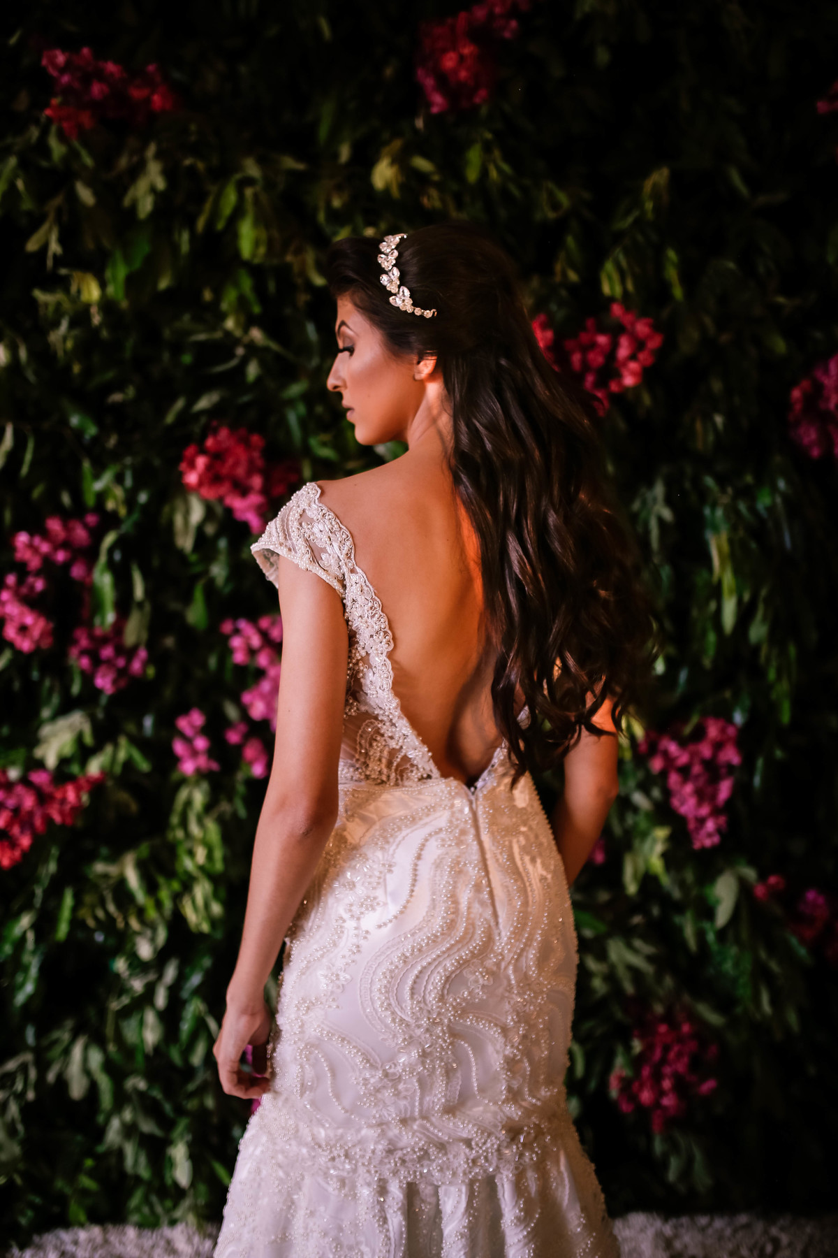 noiva de costa olhando pras flores rosas