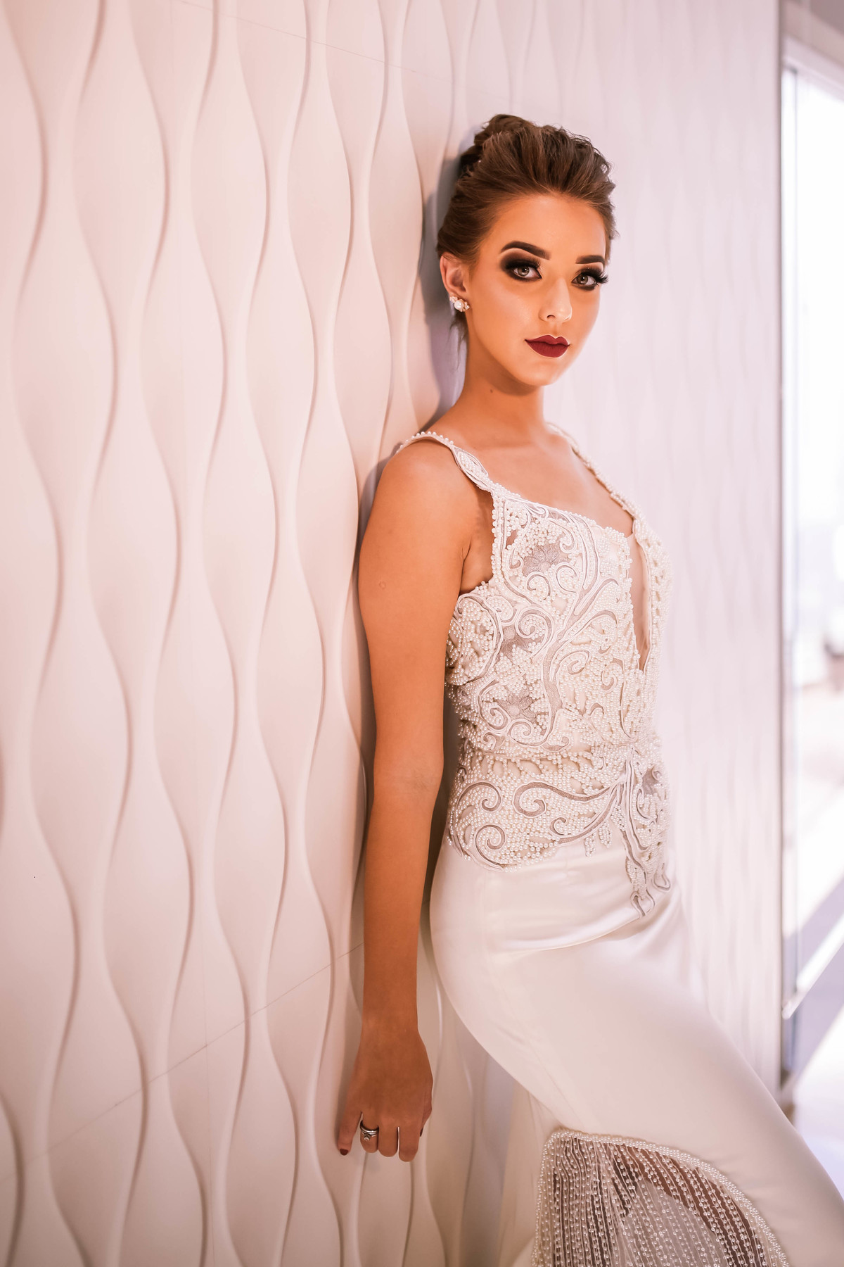 mulher encostada numa parede bege