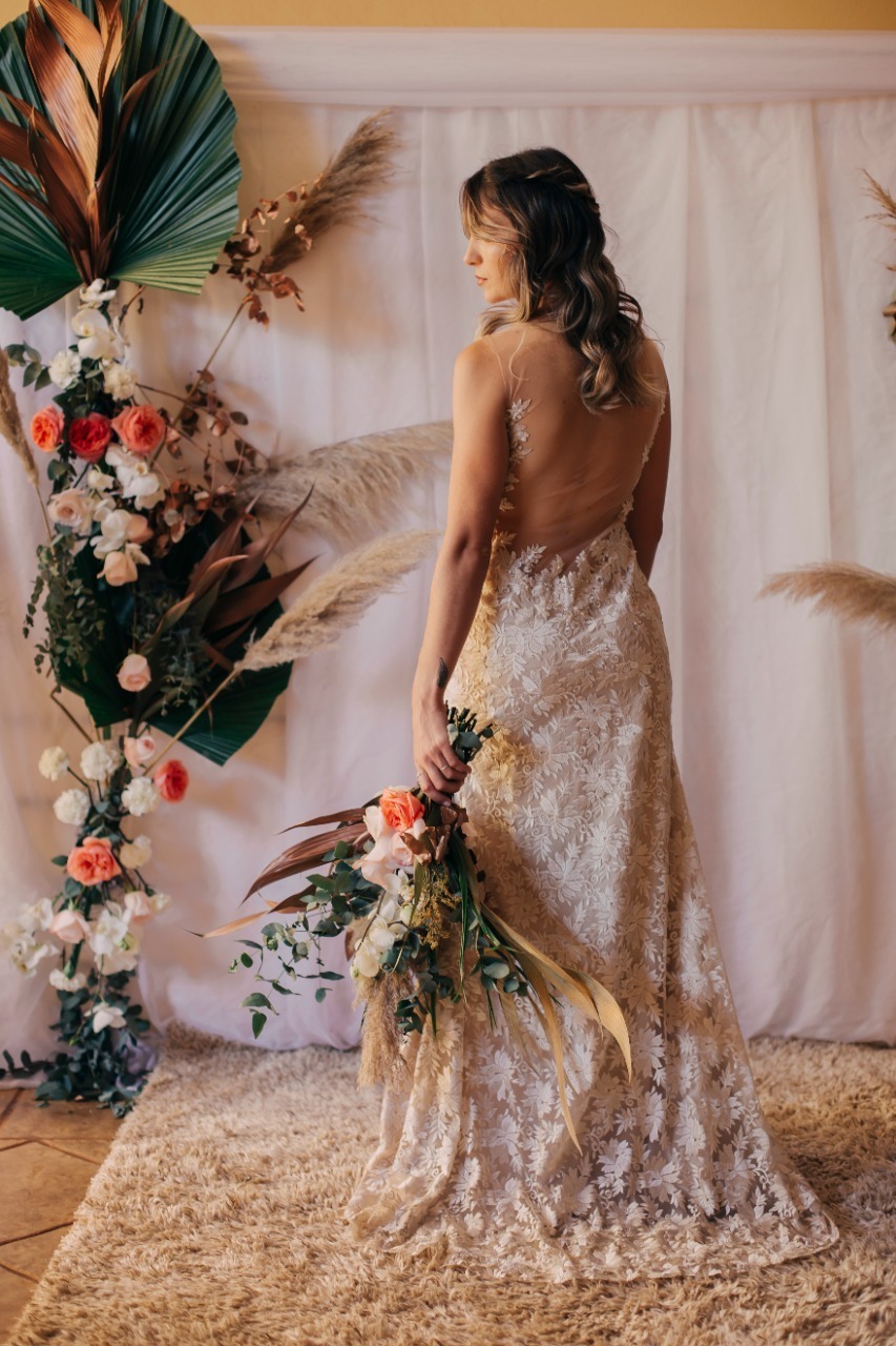 mulher de costa com flor na mao