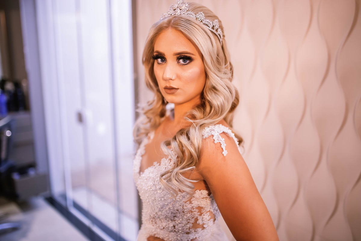 moça de vestido branco com maquiagem olhando pra frente