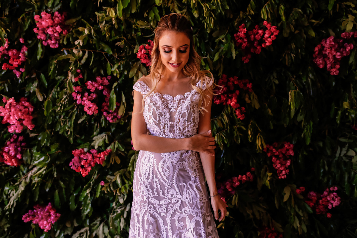 mulher com vestido branco na frente de flores rosas 