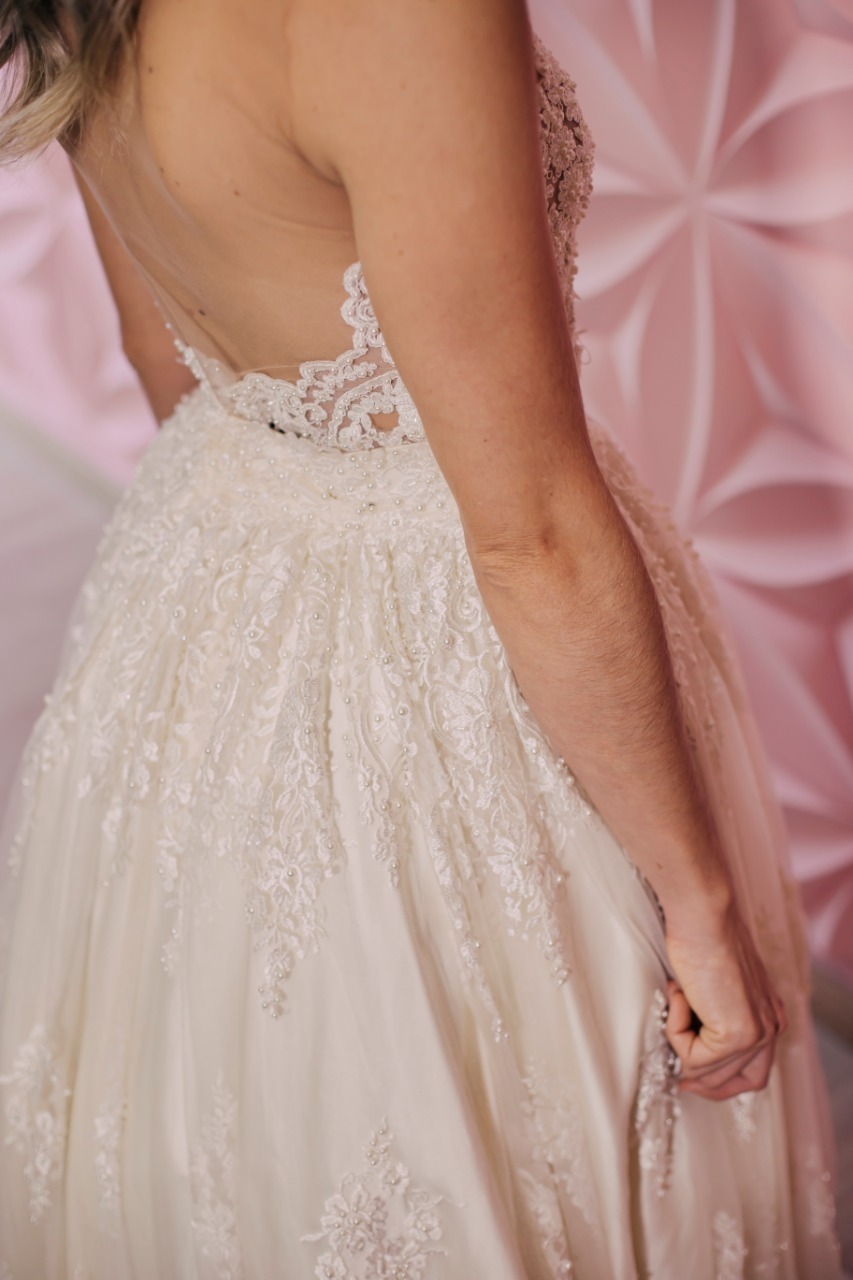 parte traseira de um vestido branco com parede rosa atrás 