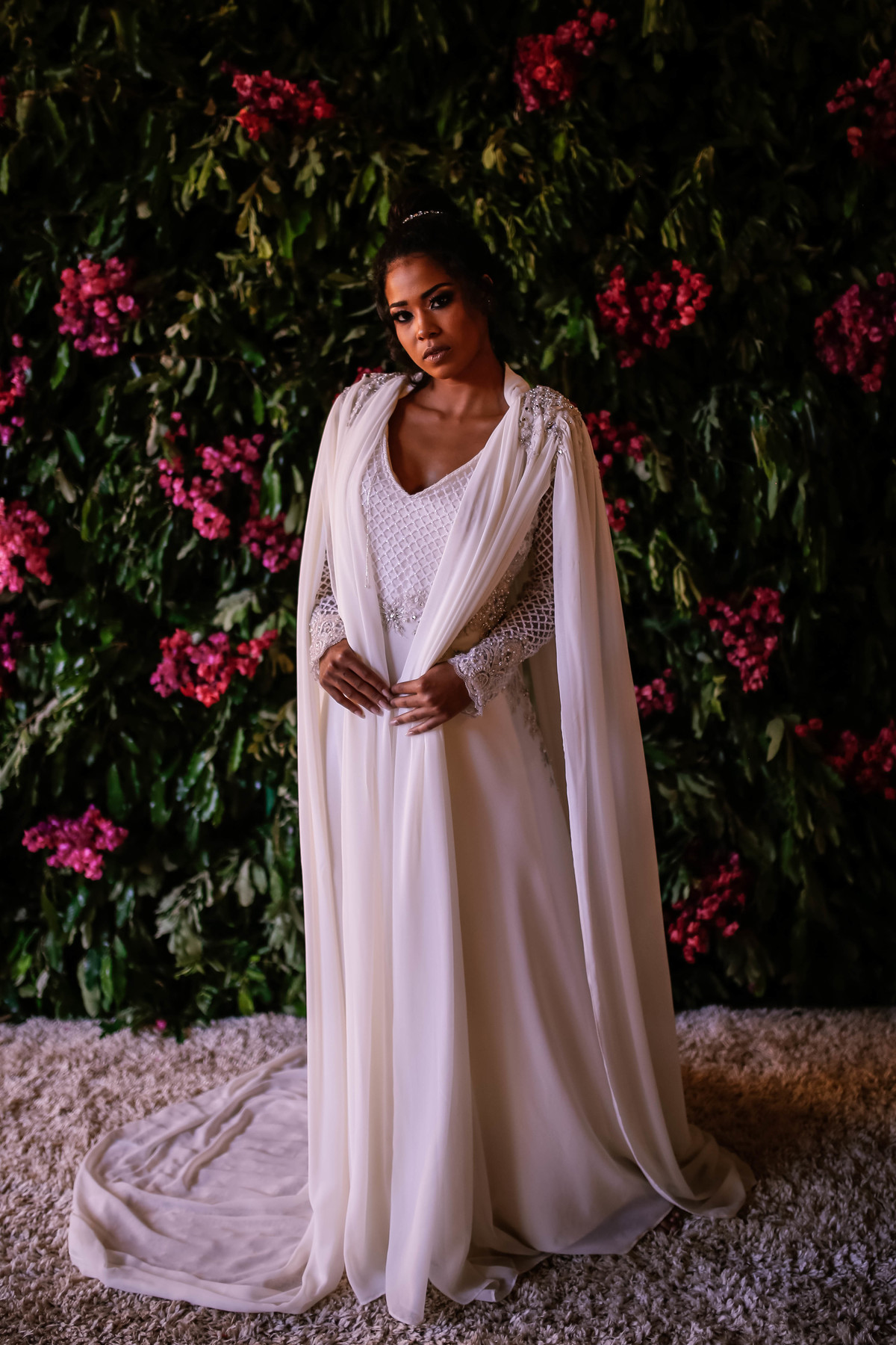 mulher morena em frente a flores rosas