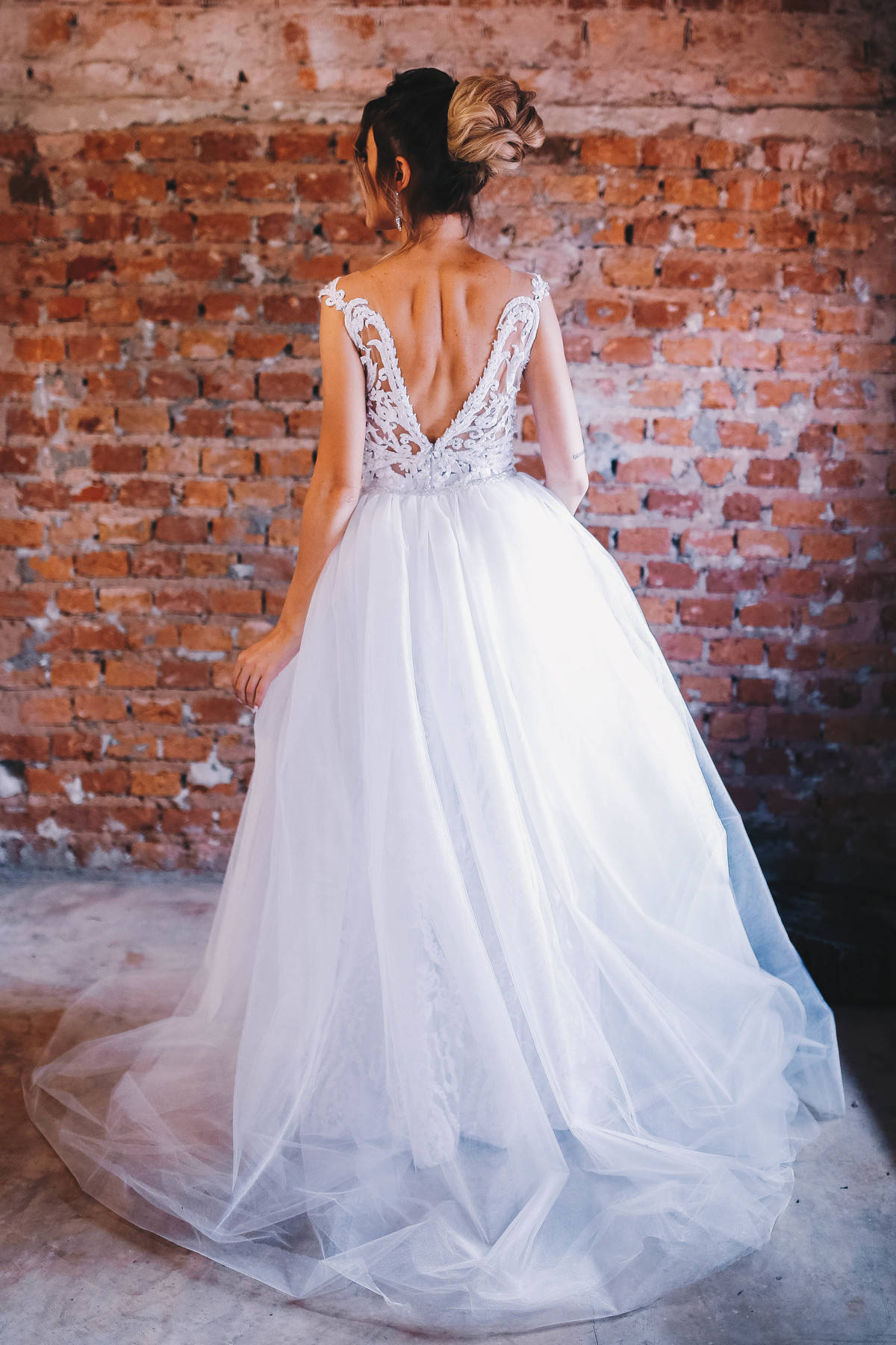 parte traseira de um vestido branco em frente a parede de tijolos