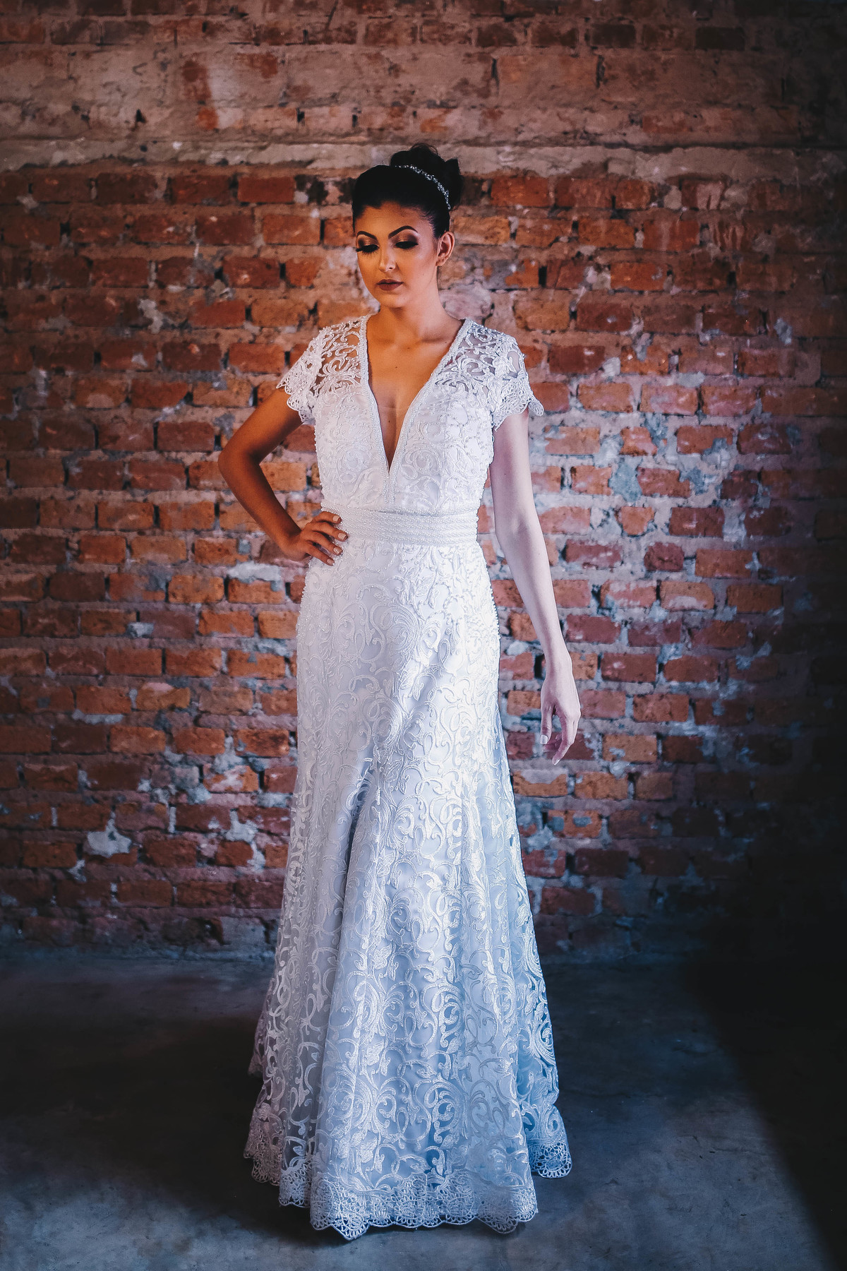 vestido branco em frente a parede a tijolos 