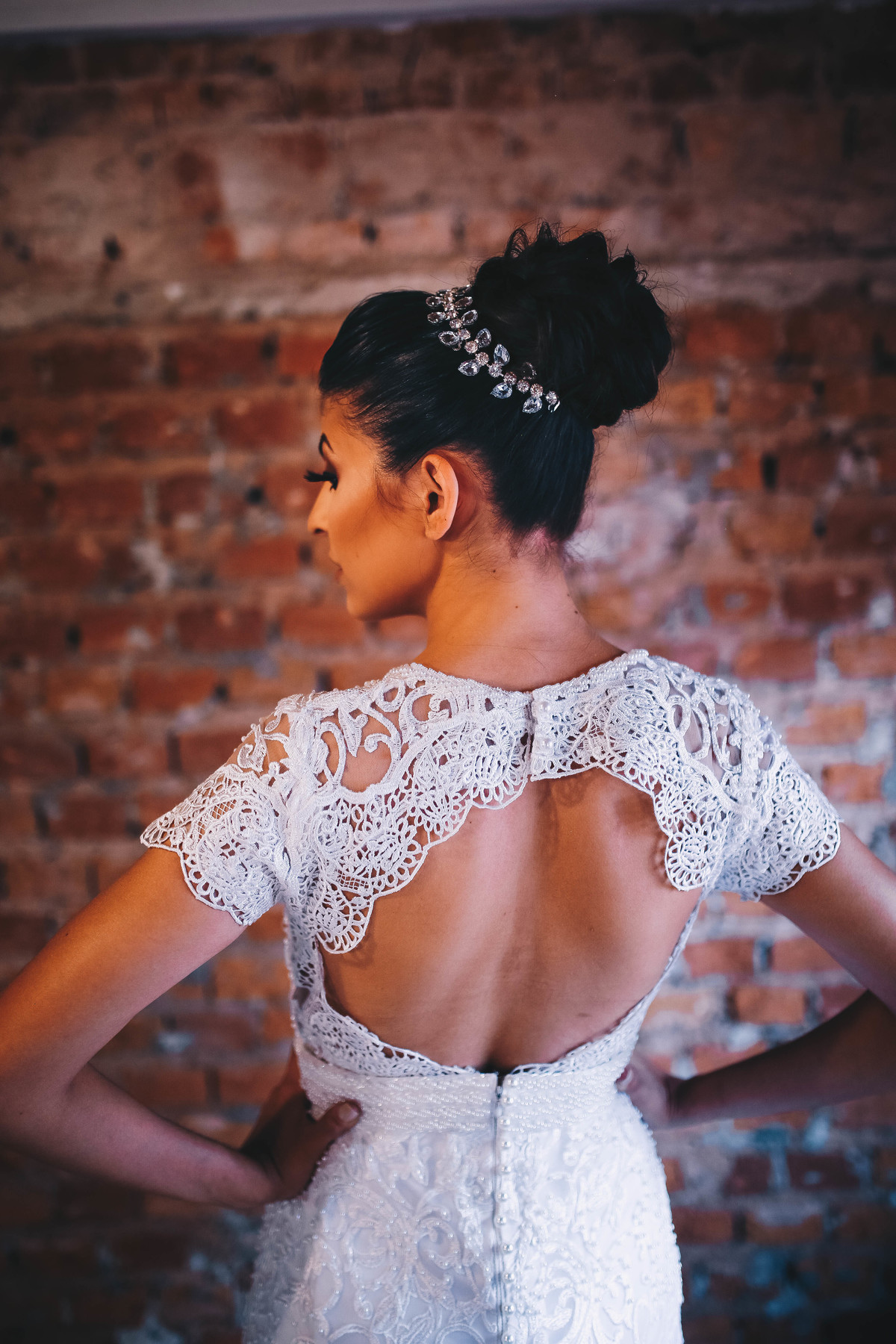 vestido na parte de costas em frente a parede de tijolos 