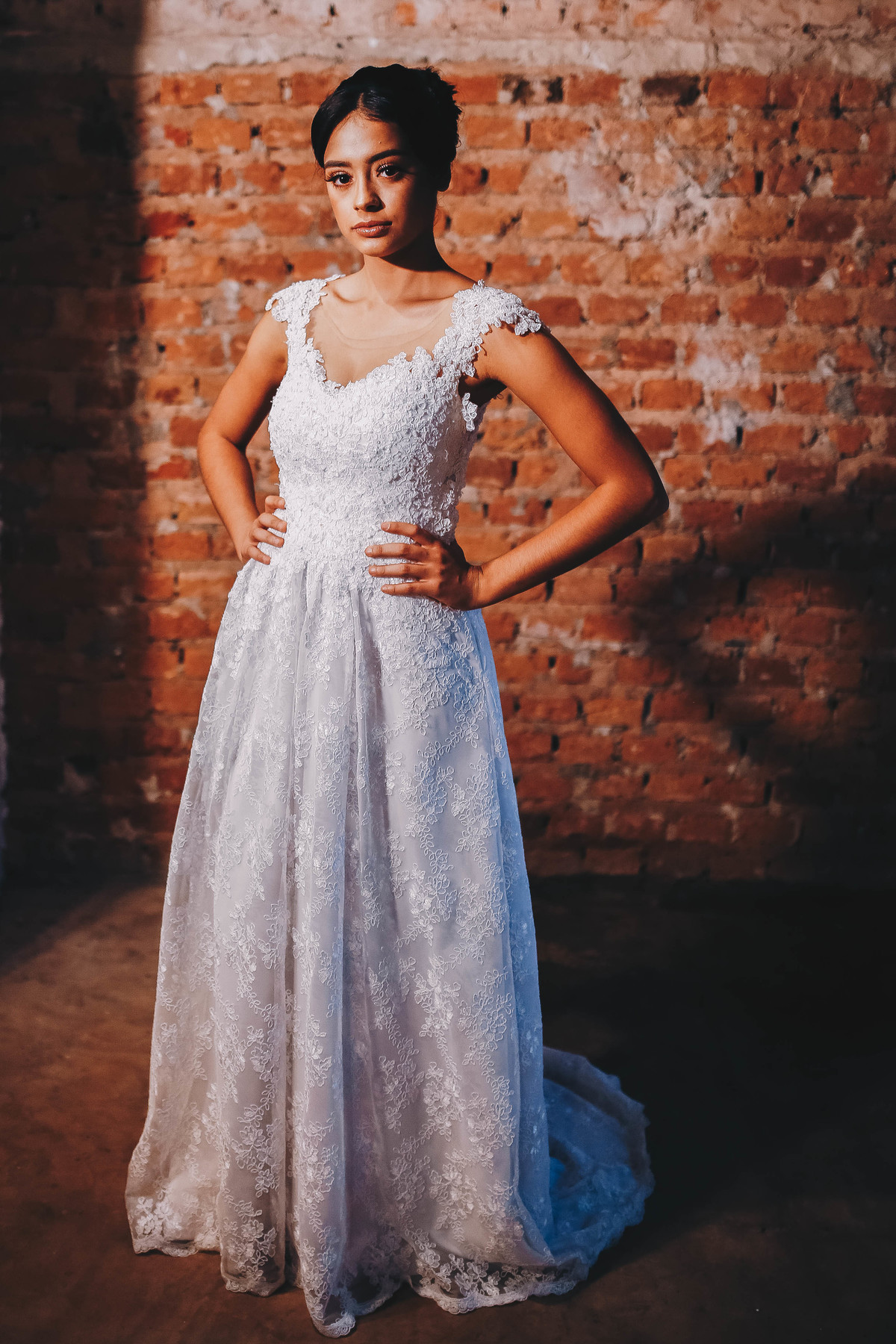 vestido branco em frente a  parede de tijolos 