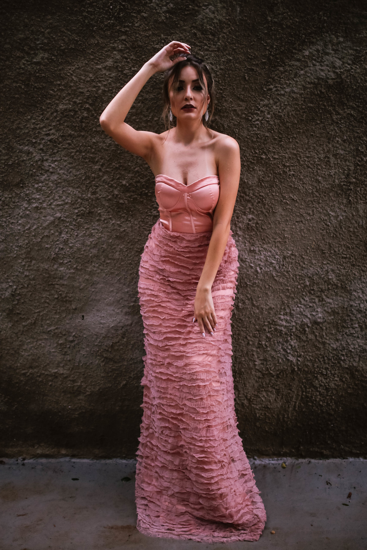 vestido rosa em frente a parede de terra