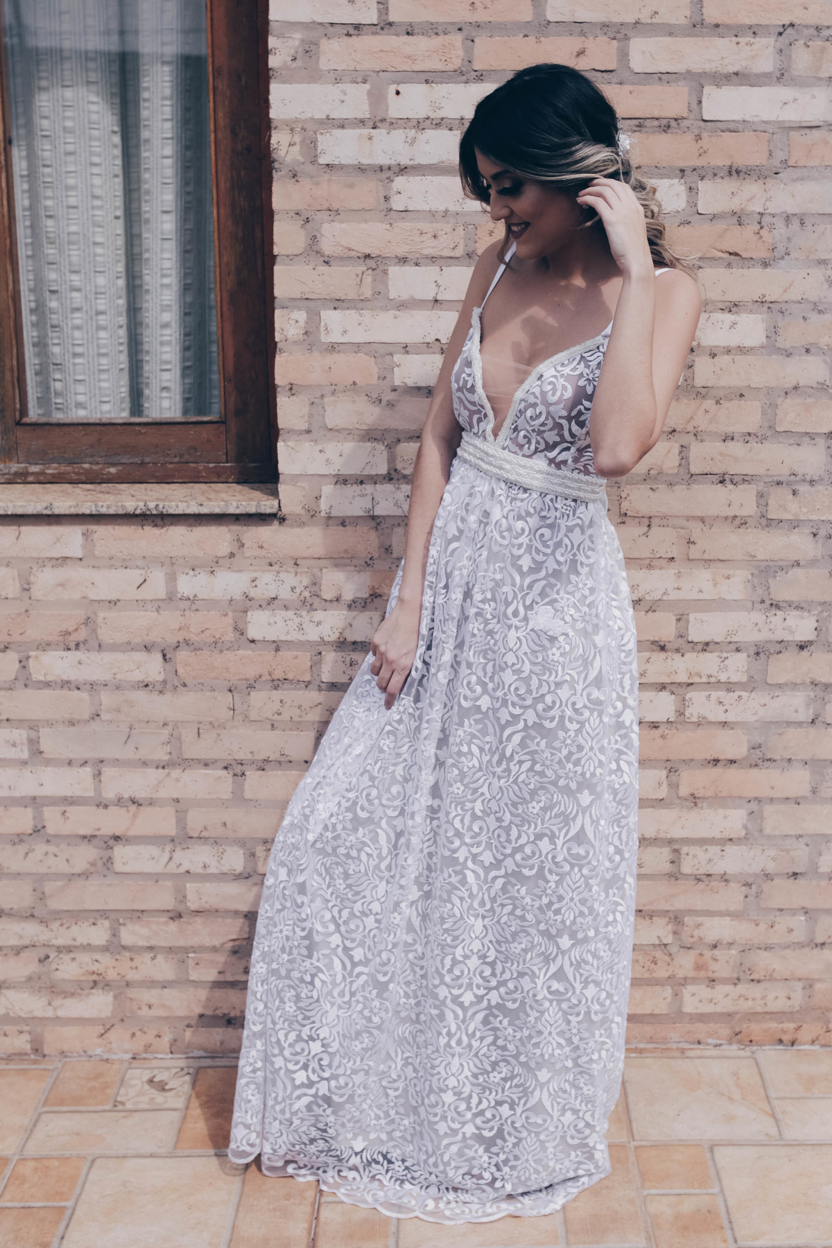 vestido branco em frente a parede de tijolos