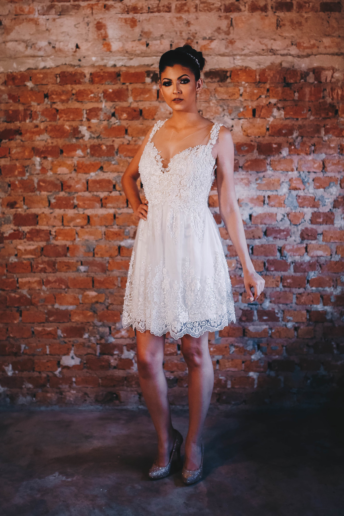 vestido branco em frente a  parede  de tijolo 
