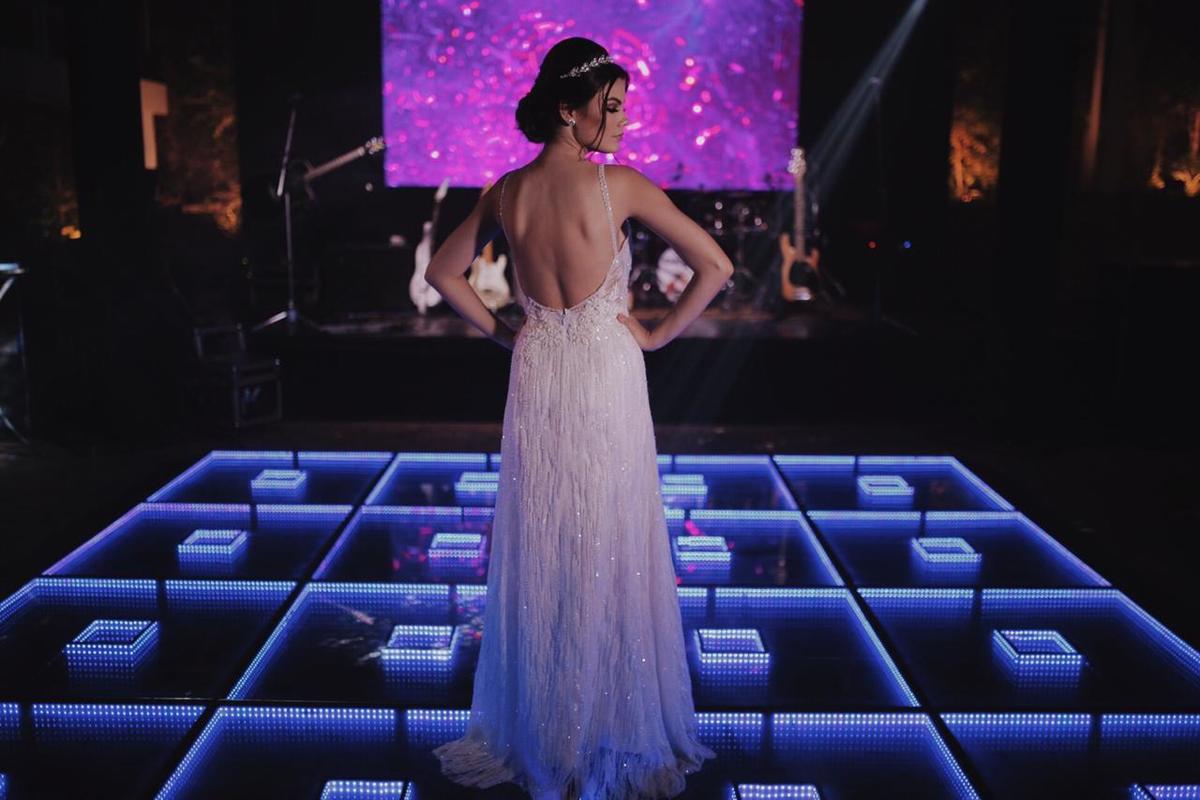 mulher de vestido de costas em cima de palco azul