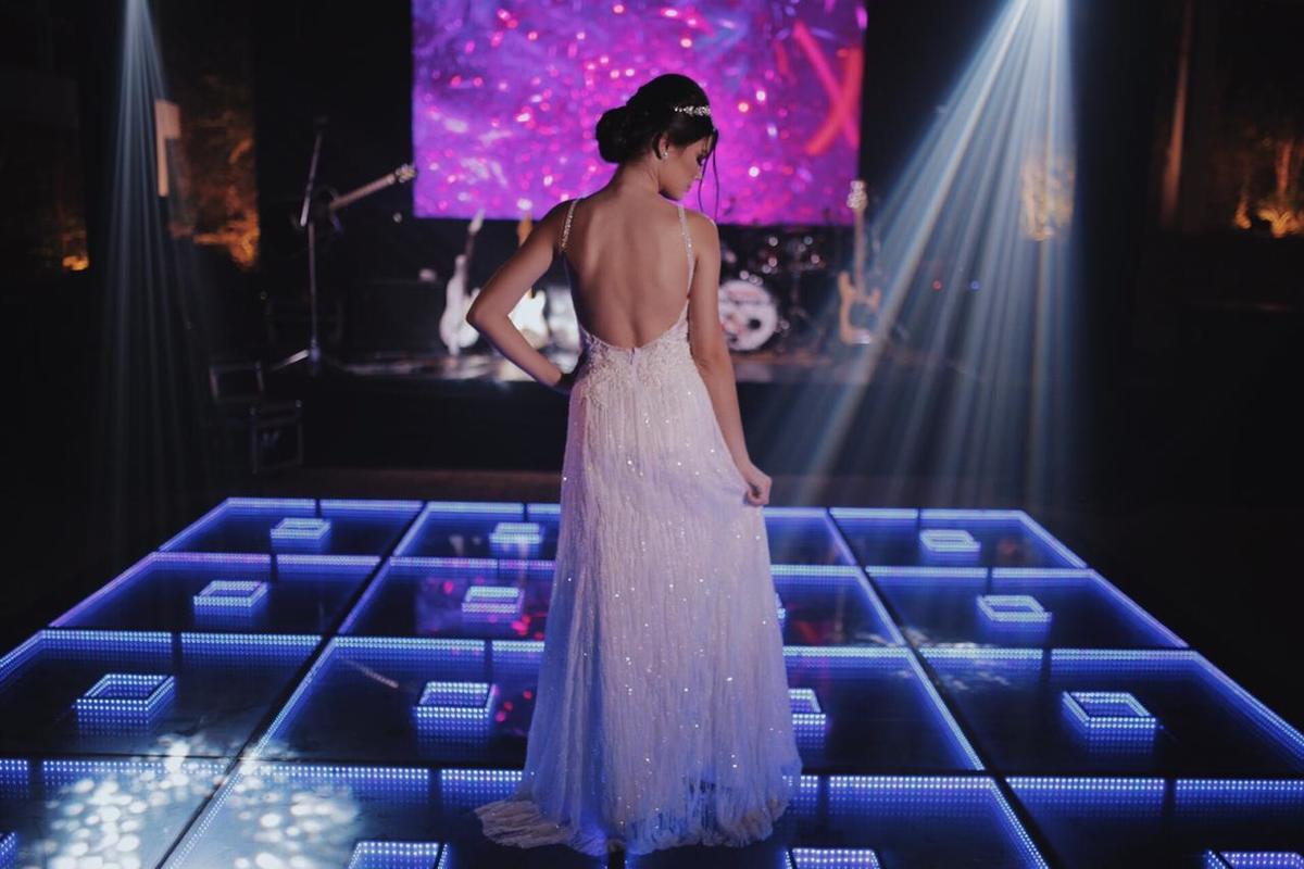 mulher de costas com vestido em cima de um palco azul