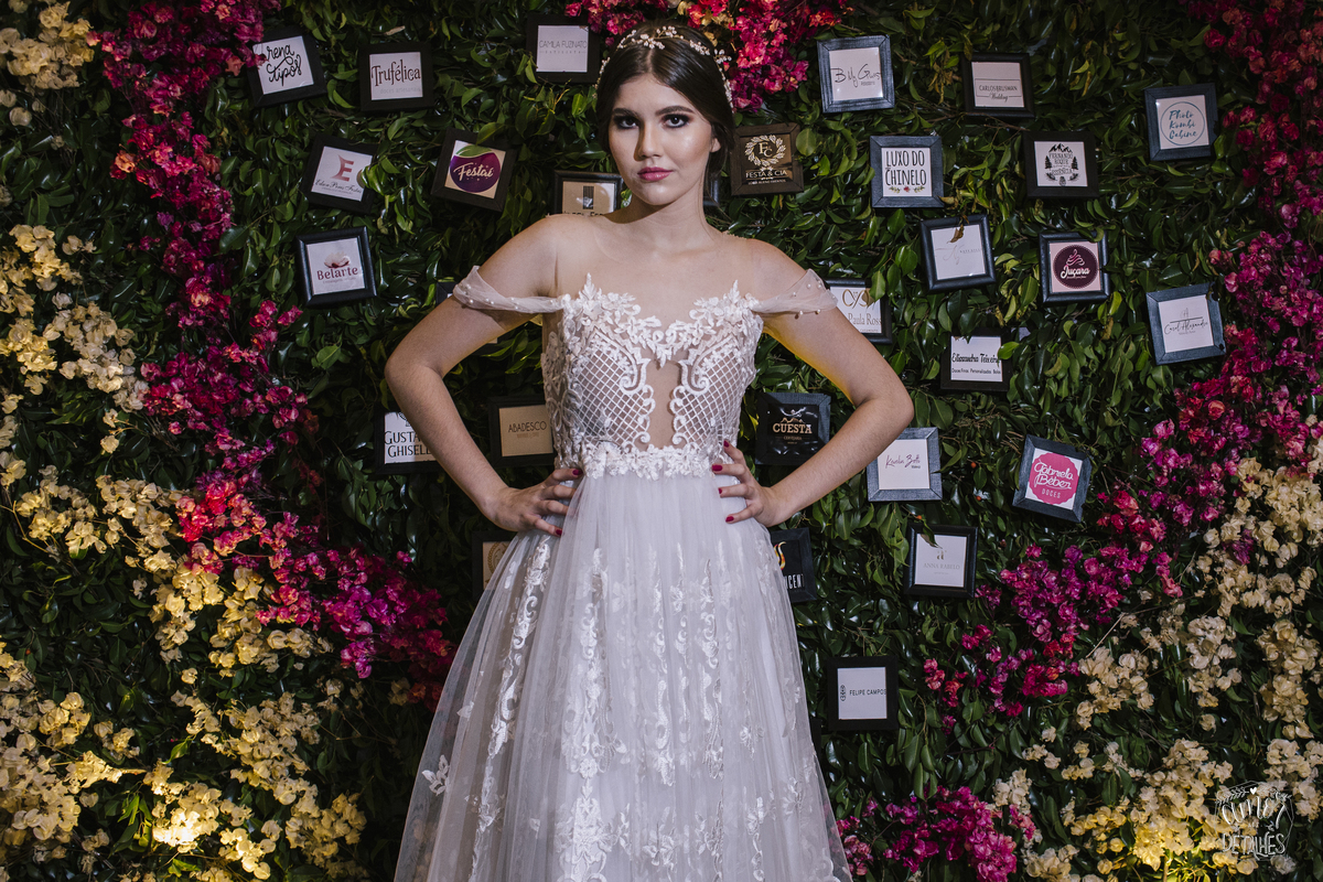 mulher de vestido branco em frente a rosas
