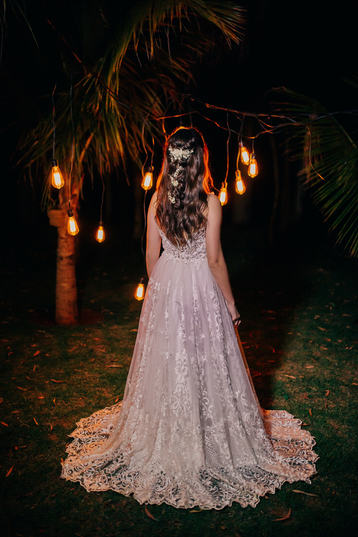 mulher de costas com um vestido branco em campo luminado