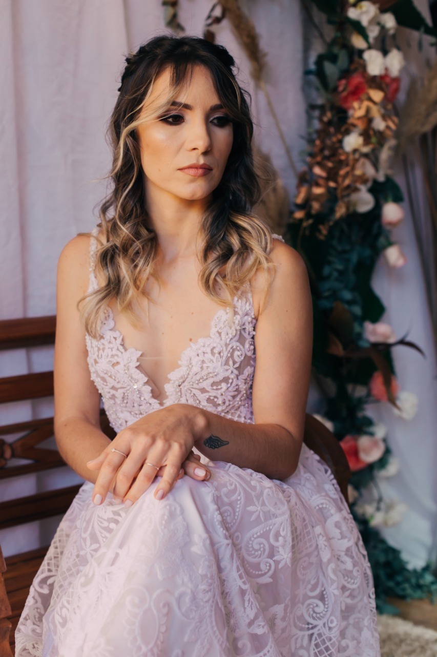 loira de vestido branco com flores pertos