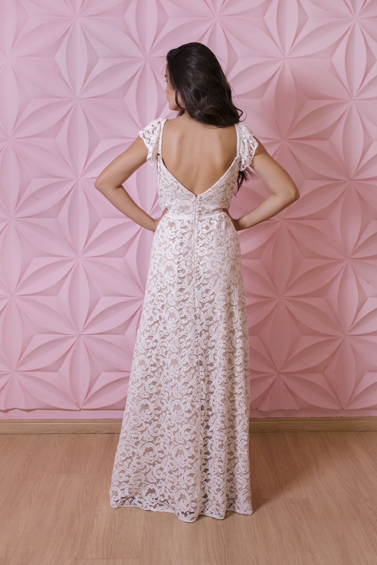 traseira de vestido branco em frente a parede rosa
