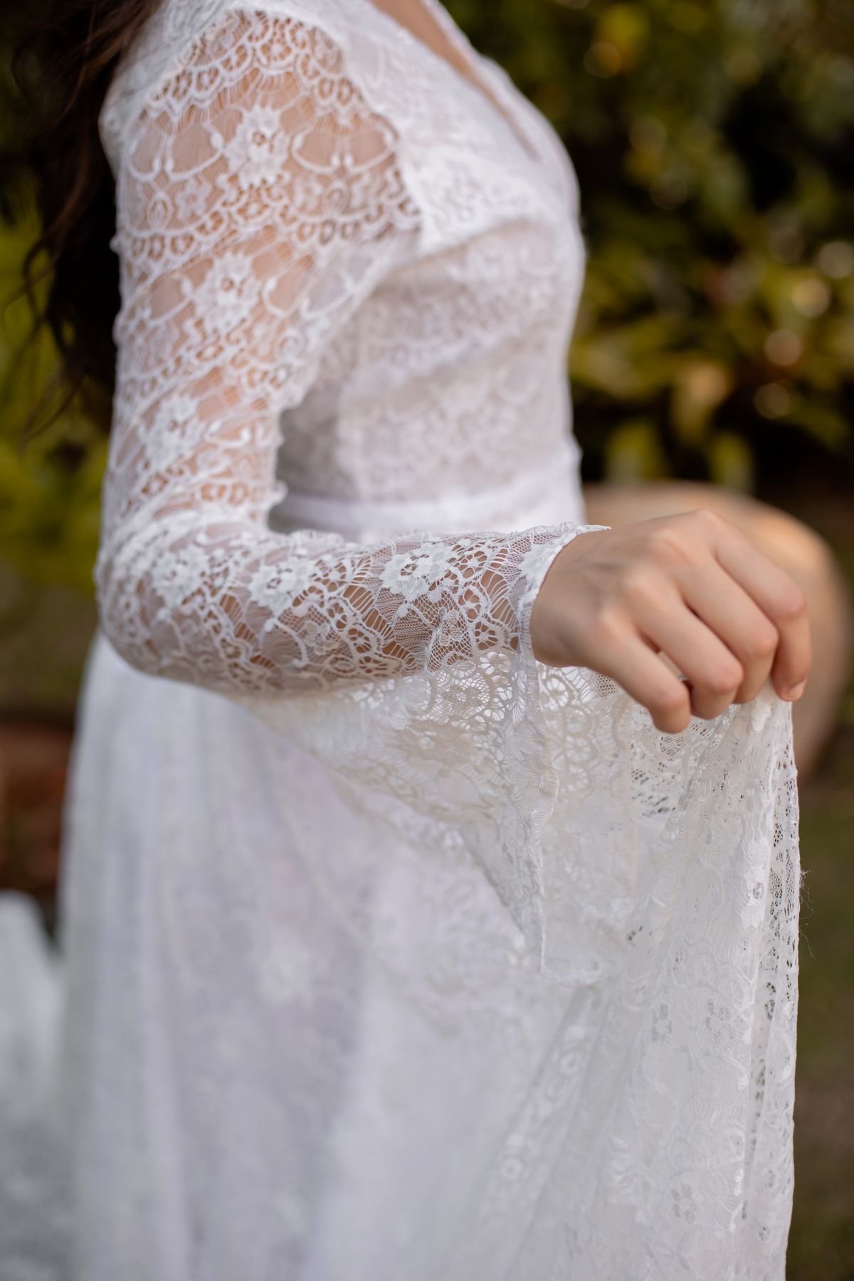 mão de mulher com vestido de noiva