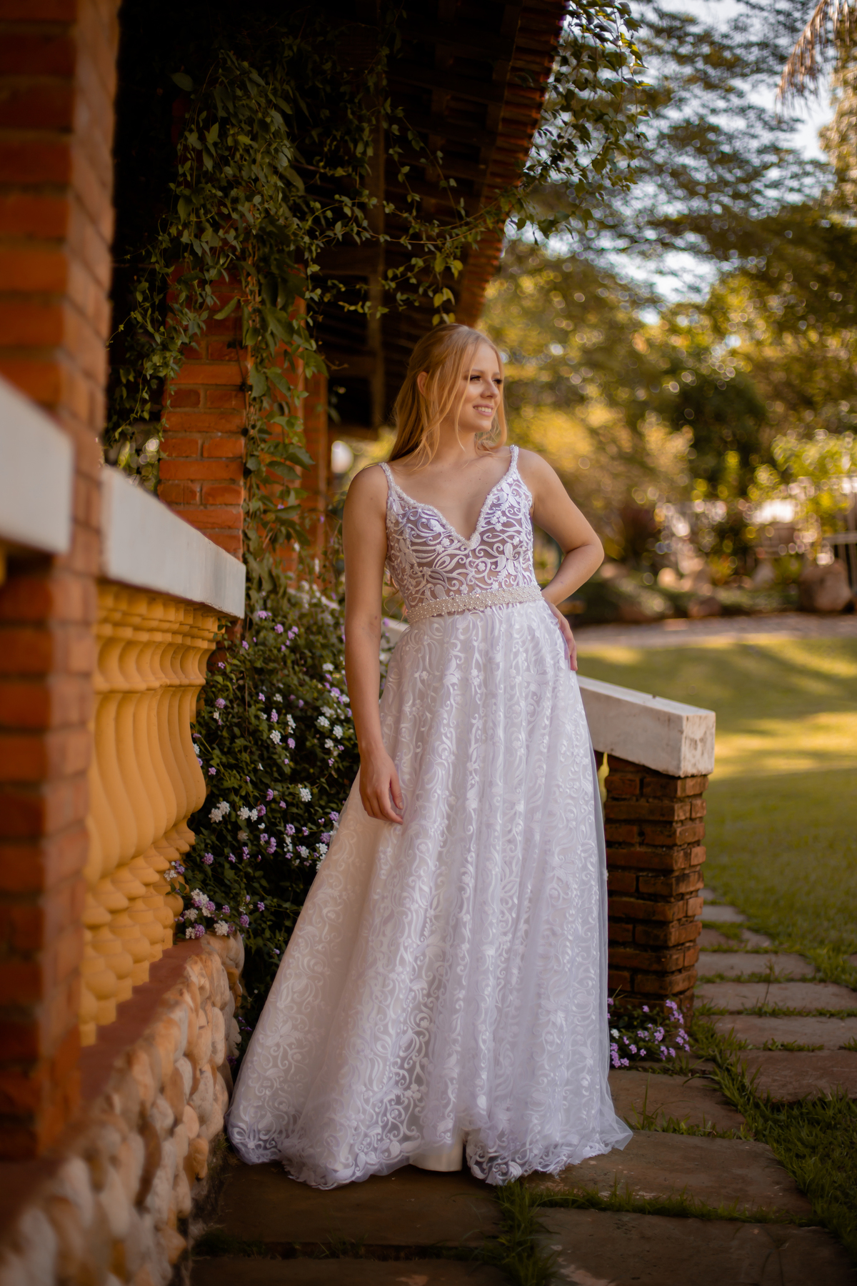 mulher loira com mão na cintura com vestido de noiva