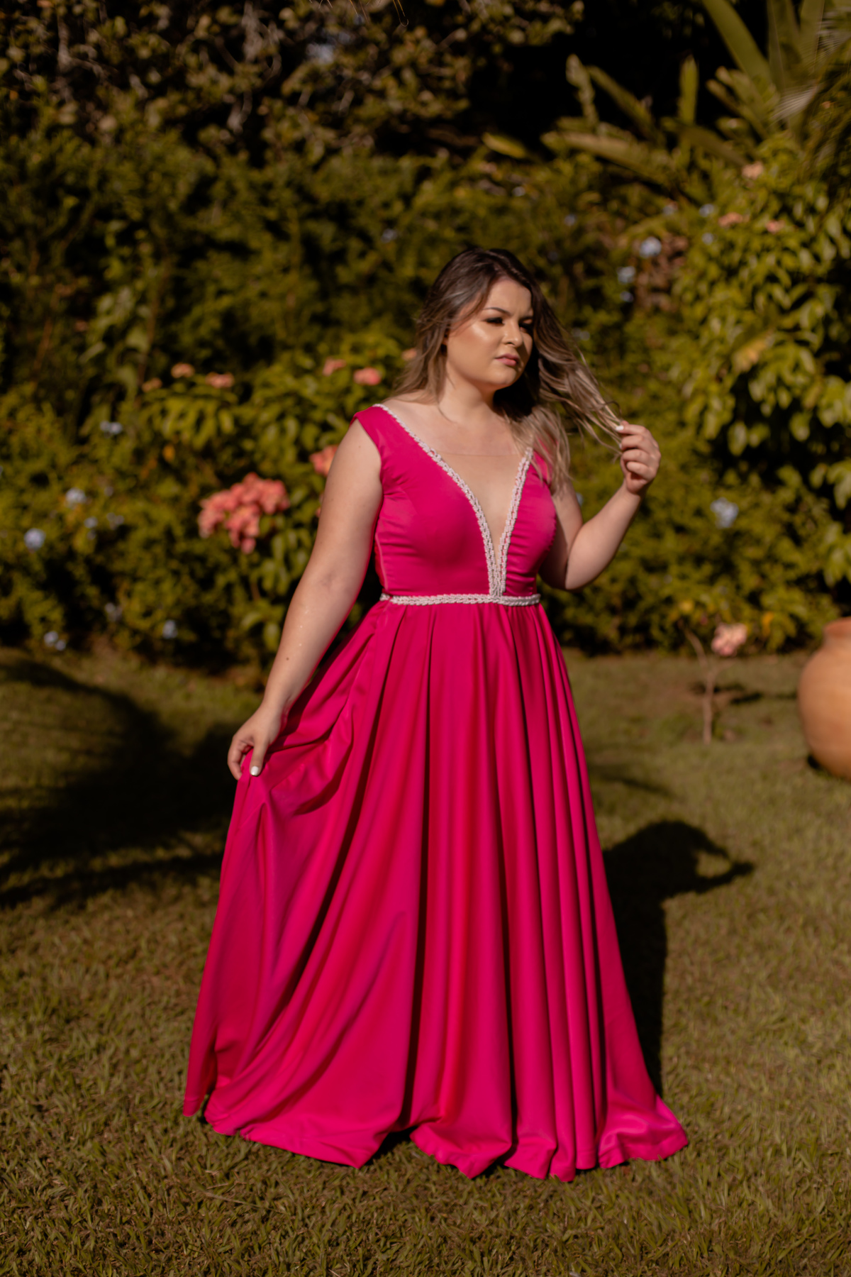 loira de vestido vermelho com arvores atrás 