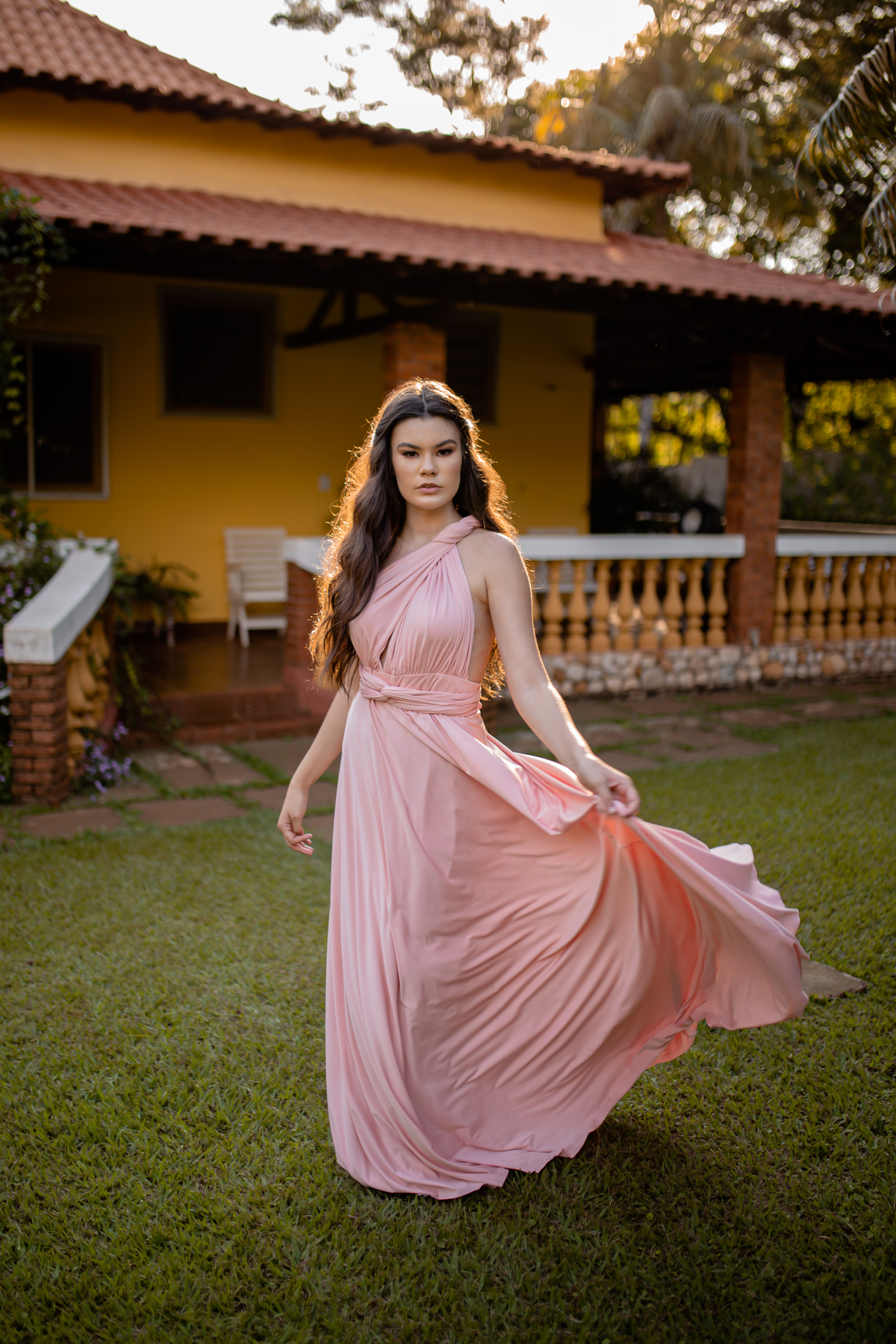 mulher de vestido rosa em um quintal  de casa