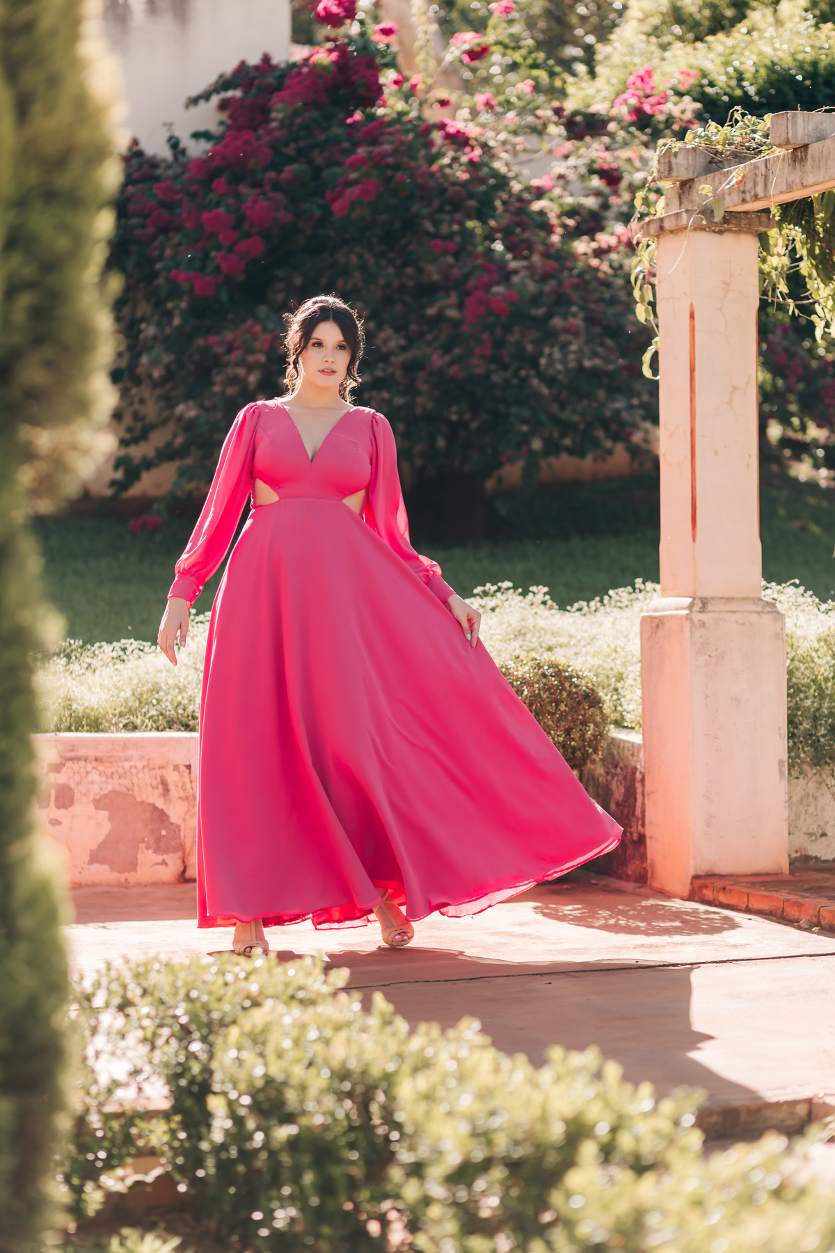 mulher com vestido de locação rosa do lado de um poste